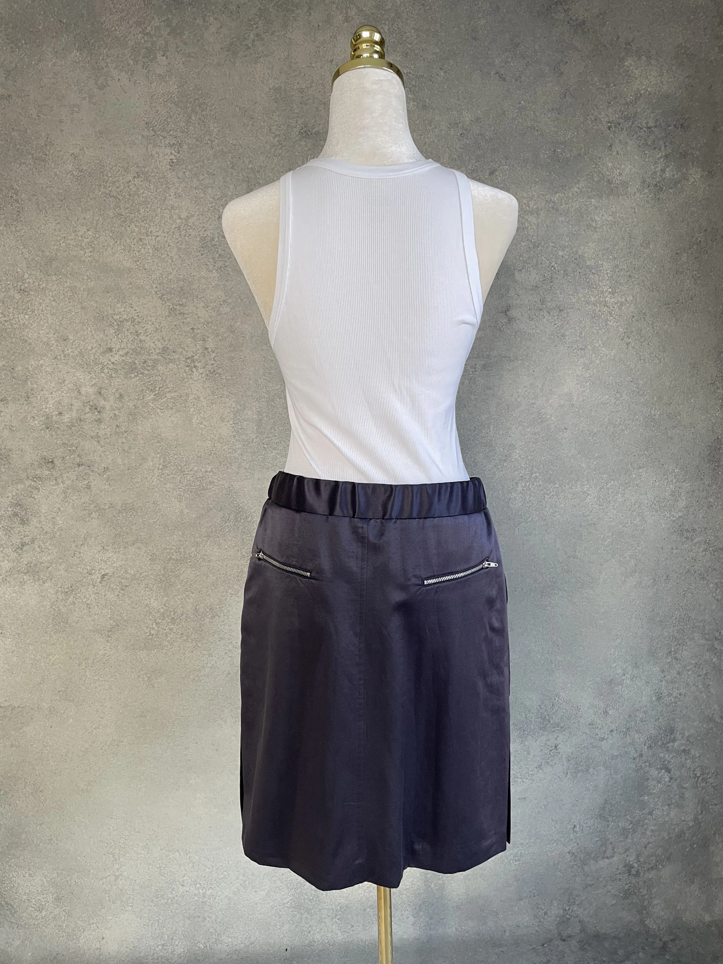 Back view of the Presque Fini skirt showing the waistband and the interior brand label.