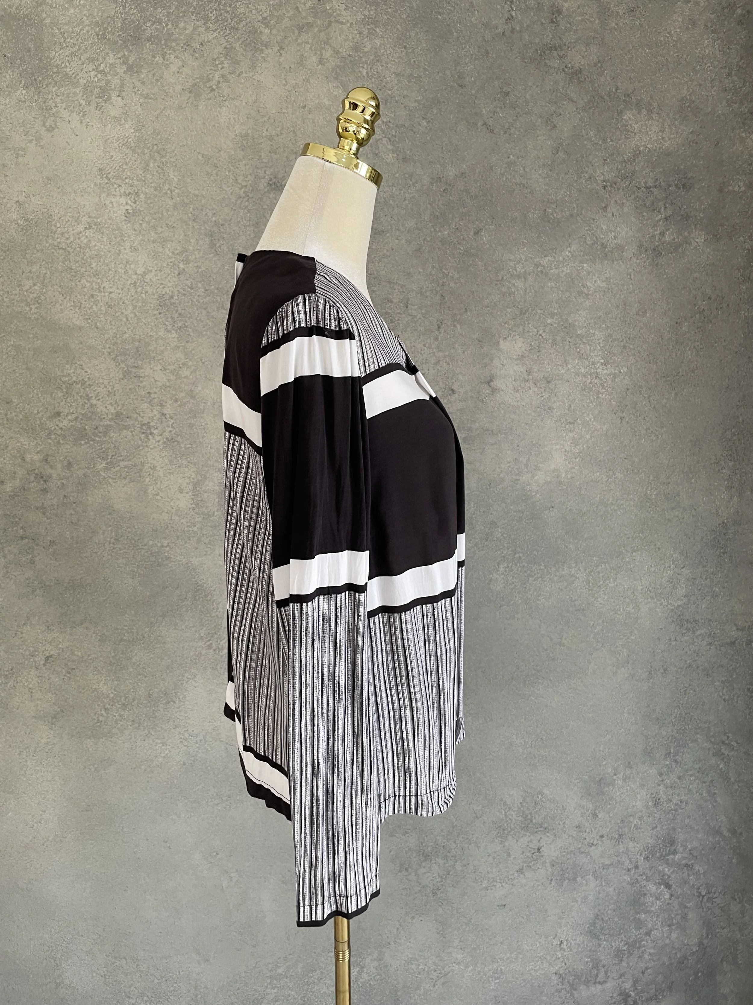 Side view of the Rodebjer graphic black and white long-sleeved blouse, highlighting the mixed panel construction.