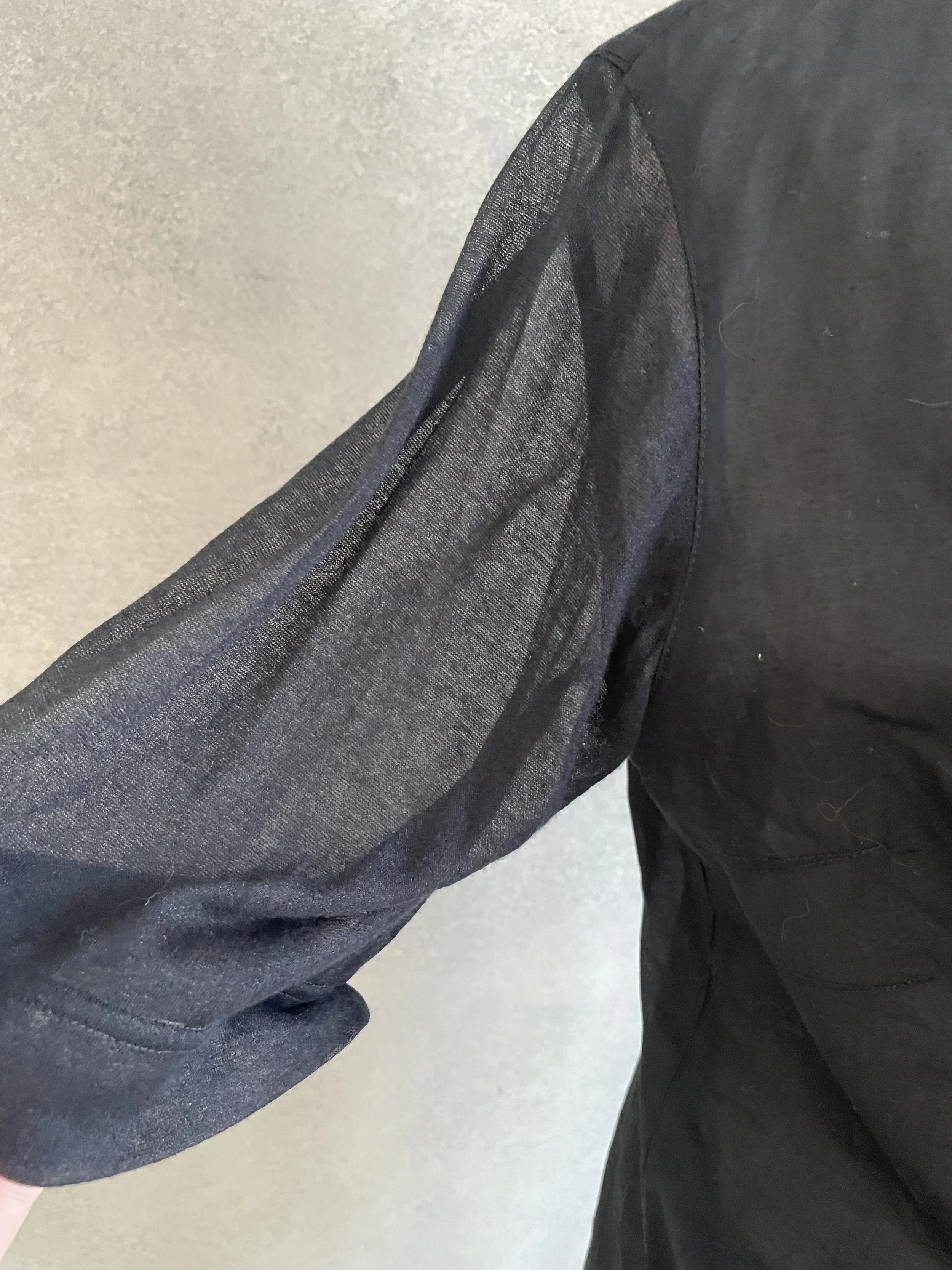 Detail shot of the Kathleen Madden black blouse sleeve and cuff, highlighting the precise stitching and refined construction