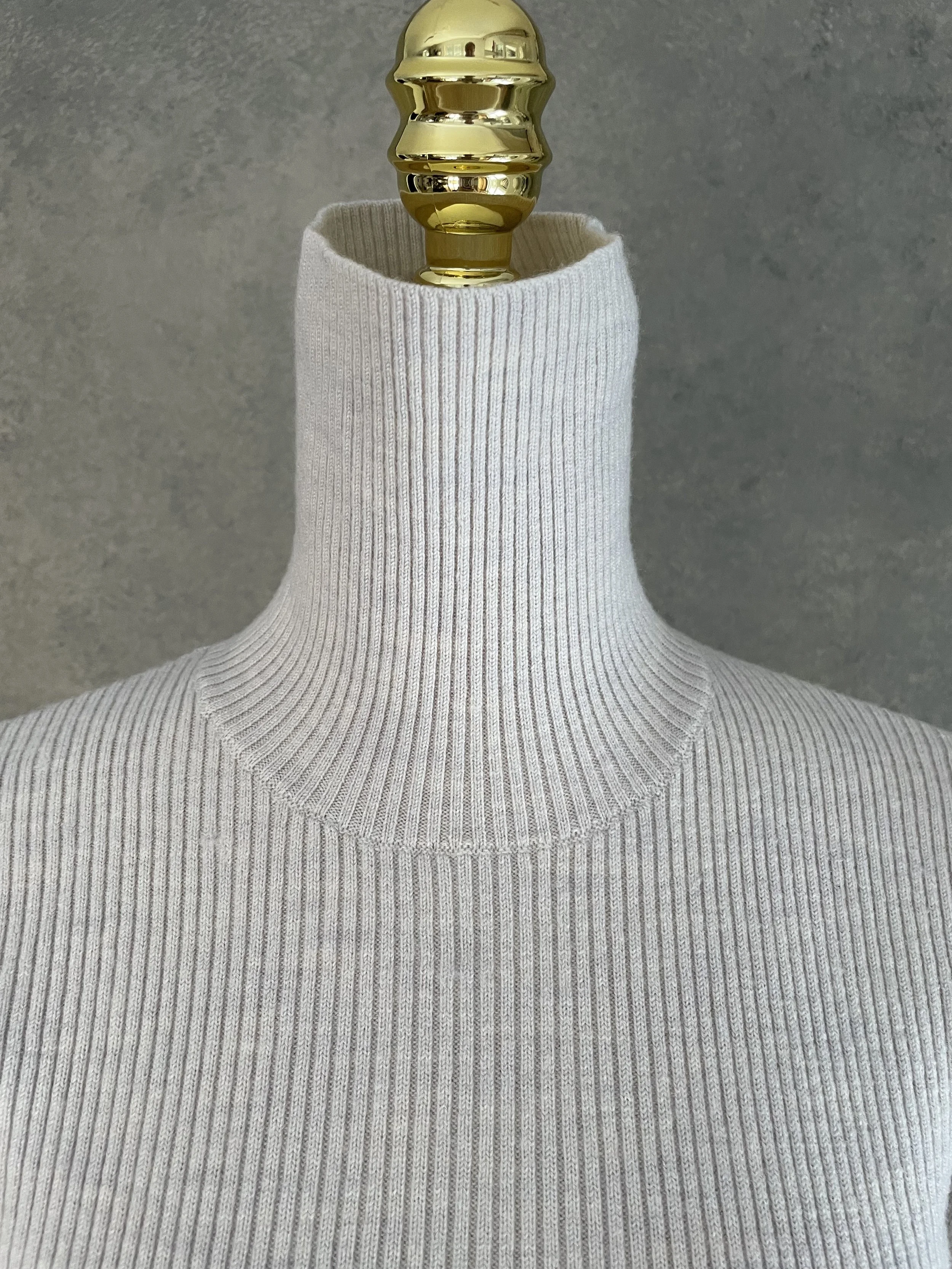 Detail view of the high-neck collar on the grey Rodebjer ribbed poloneck, highlighting the quality of the knit texture.