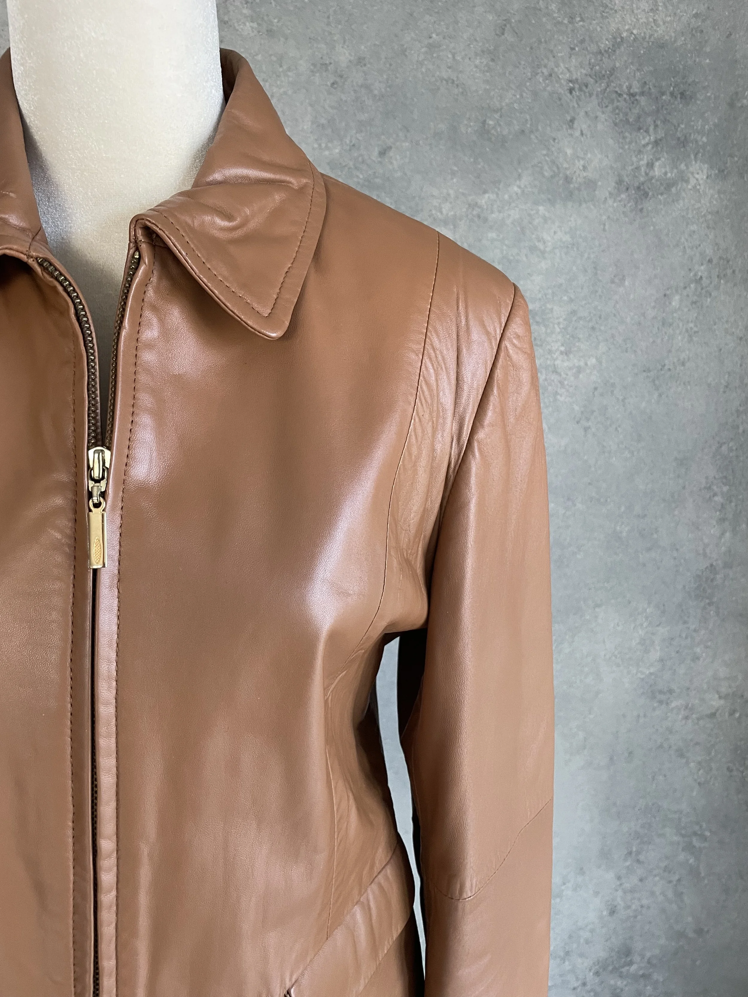 Close-up of genuine cognac nappa leather, showing the natural, high-quality grain, soft texture, and precise stitching details