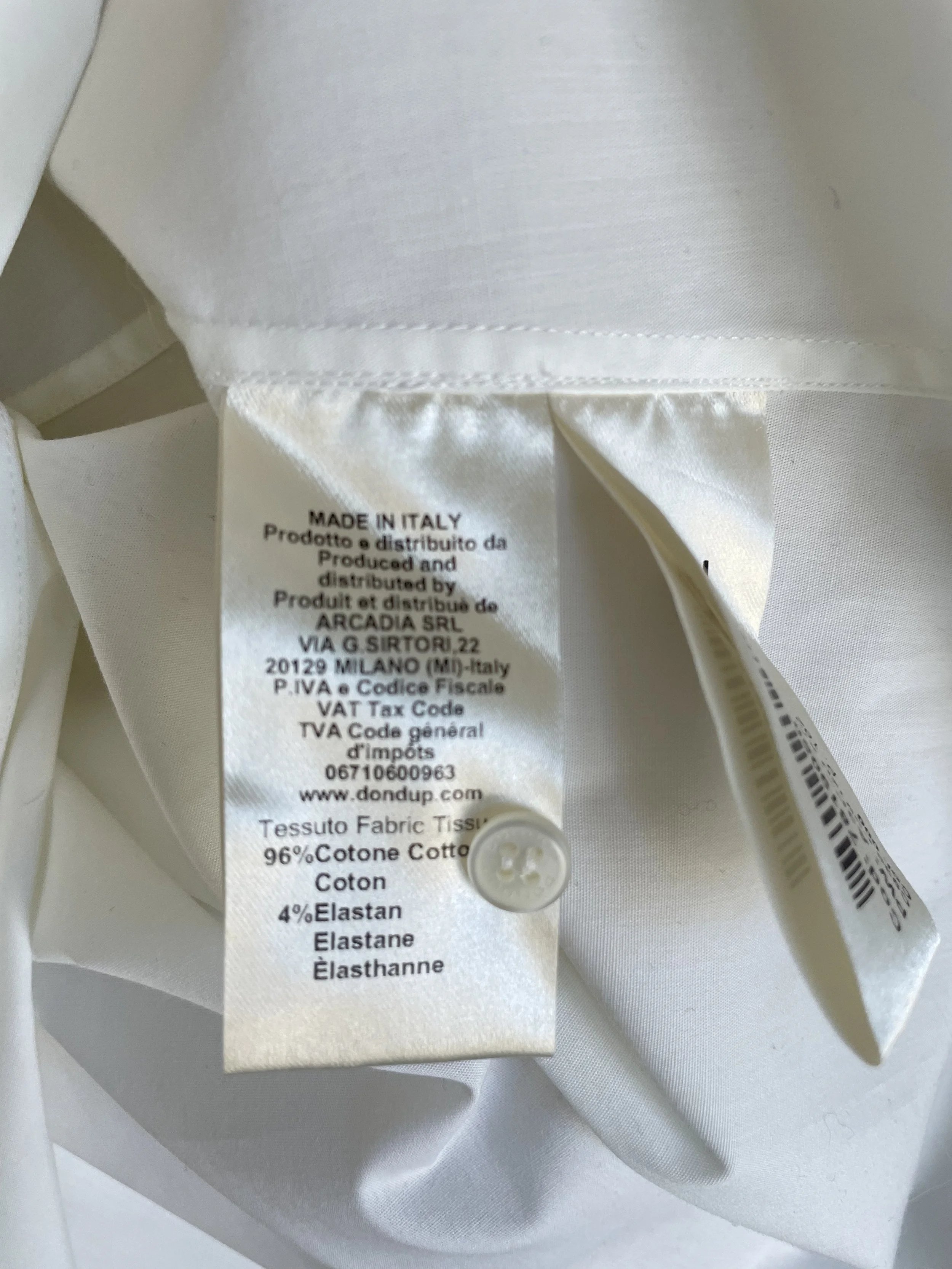 Close-up front view of the hidden button placket and standard buttons on the white Dondup shirt.
