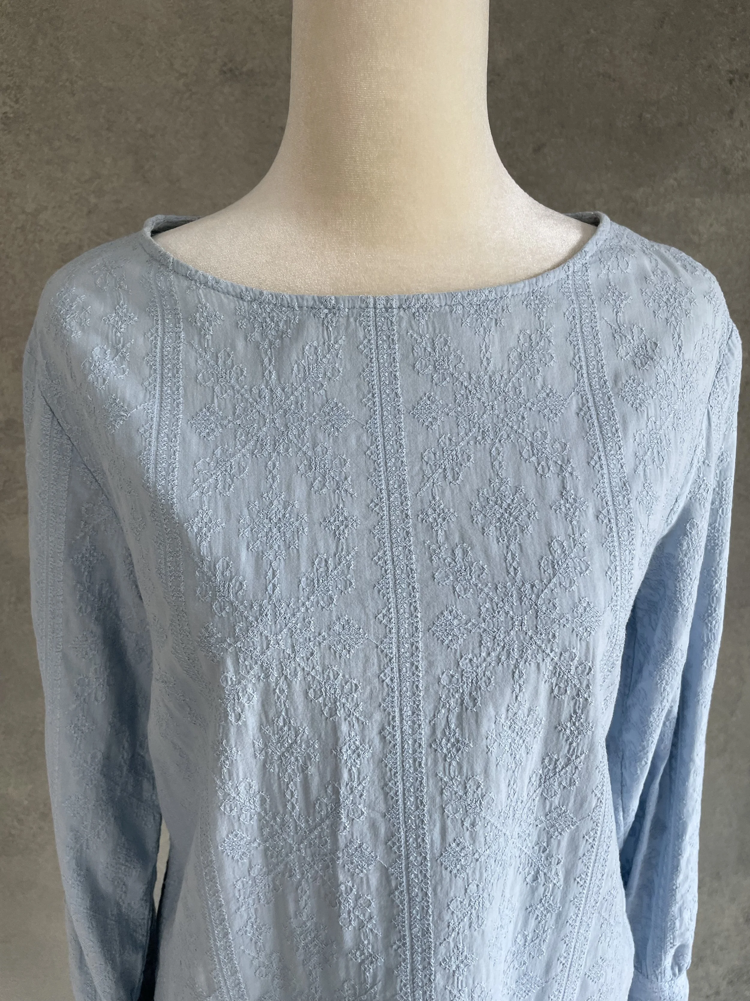 Close-up of the neckline and textured embroidery detail."