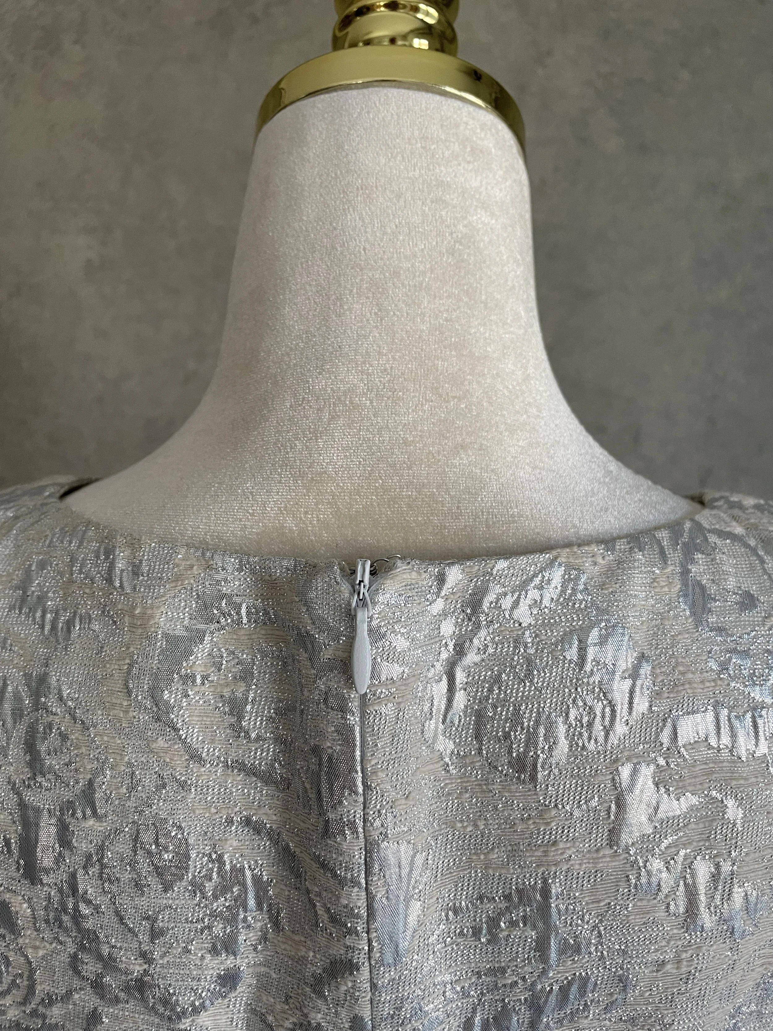 Close-up of the back neck and concealed zipper detail on the silver Scapa dress.