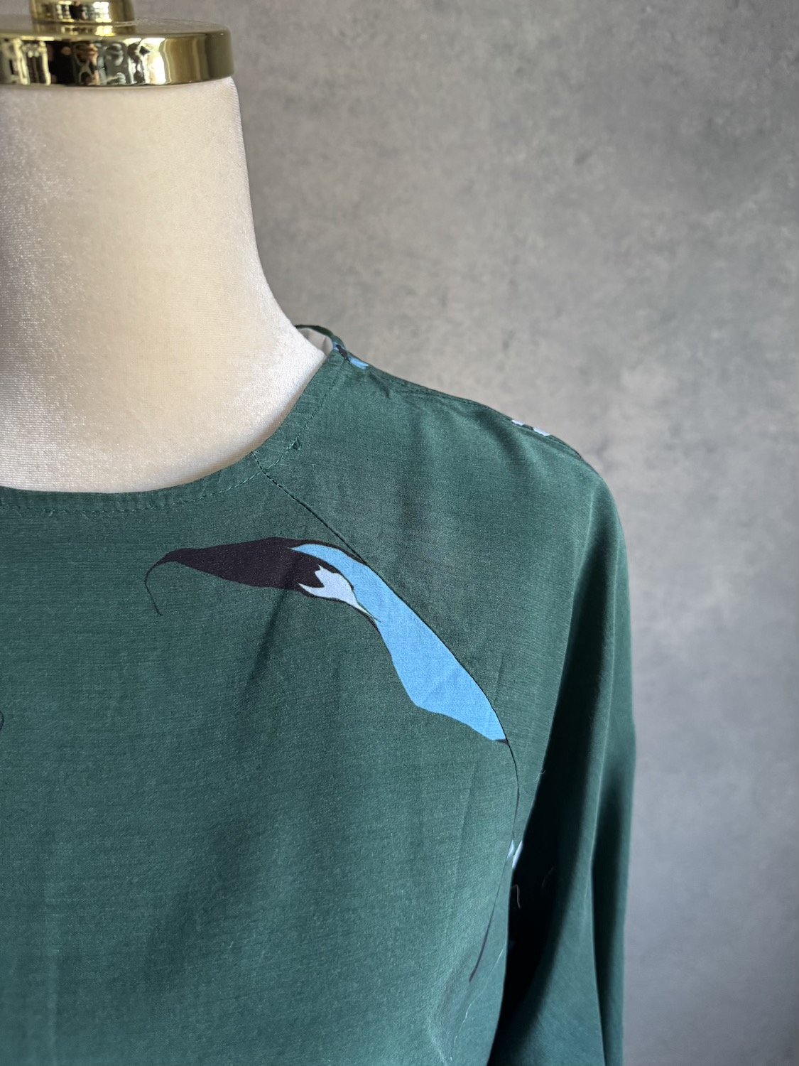 Close-up of raglan sleeve seam and graphic blue flower print on Gestuz blouse