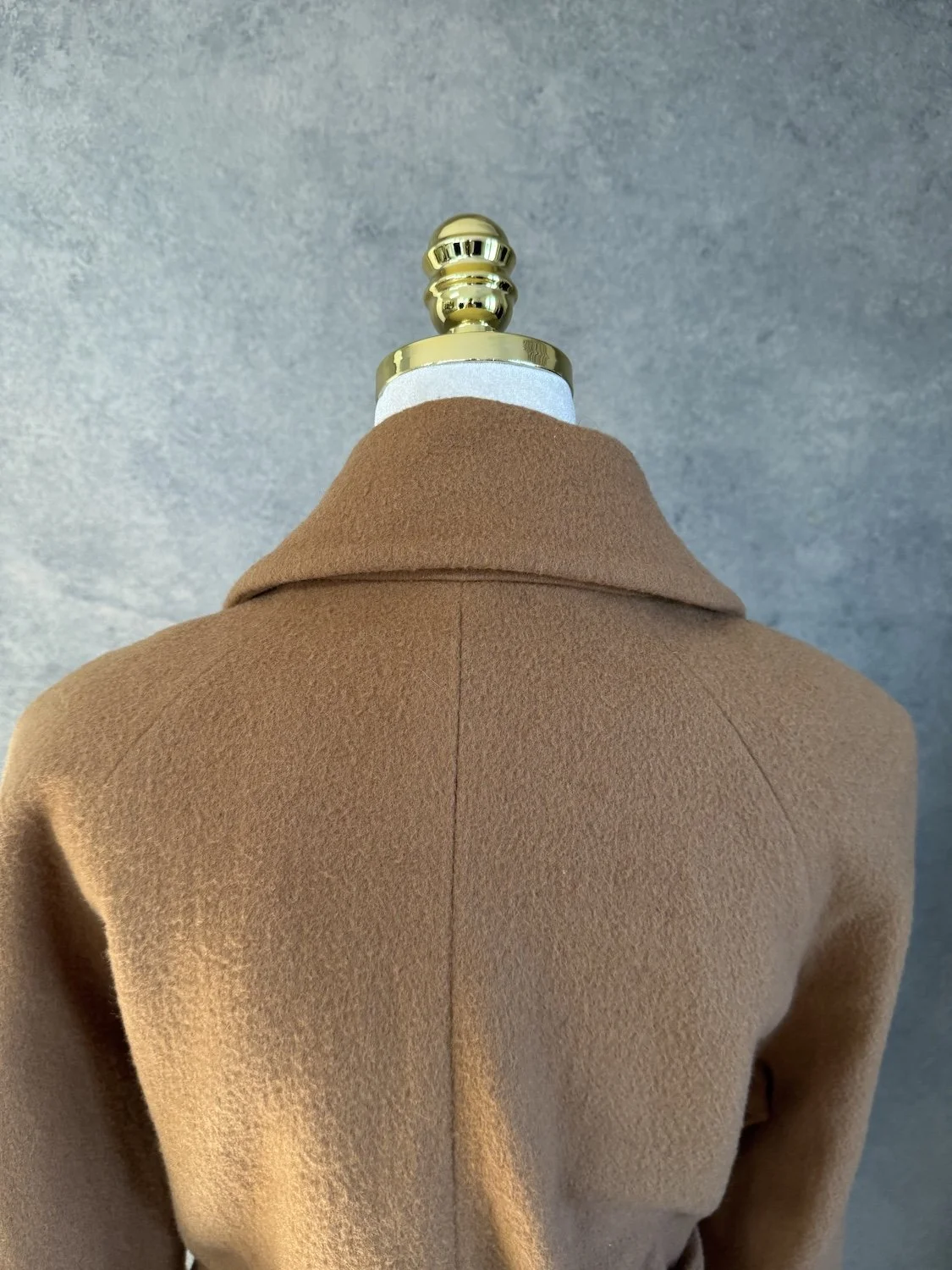 Close-up detail of the collar lapel and shoulder seam on the mannequin.