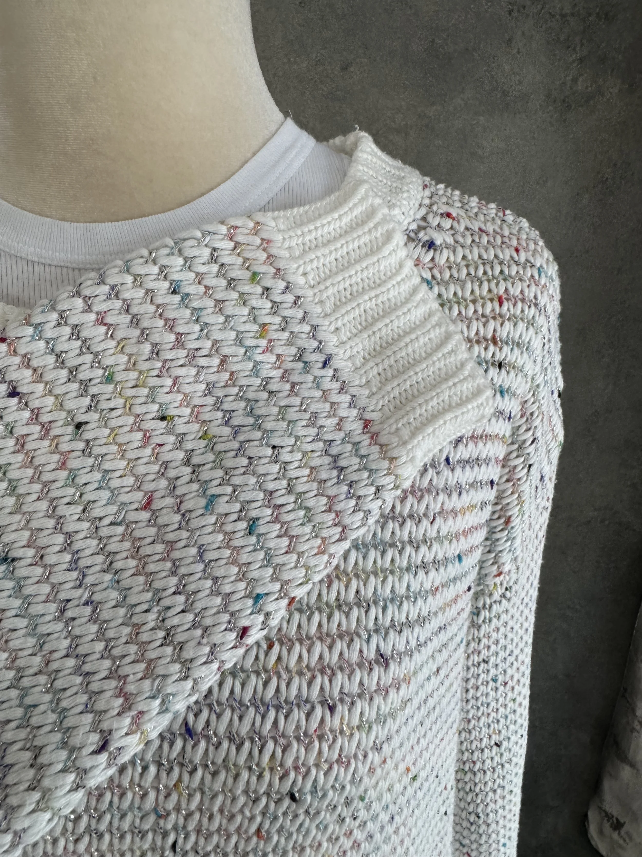Detailed close-up folded view of the textured knit fabric, emphasizing the multicolor colorway and metallic shimmer.