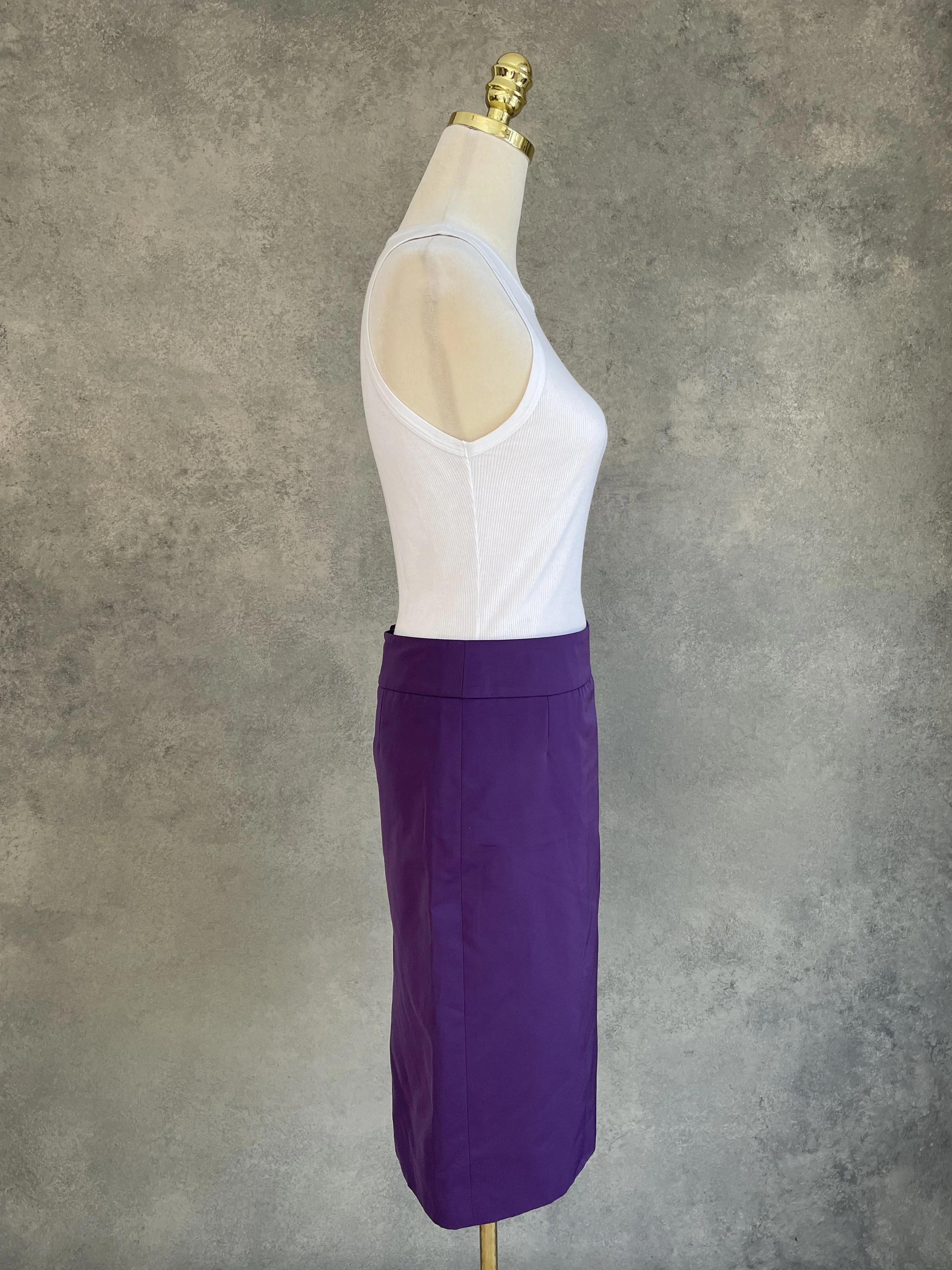 Side profile view of a tailored purple pencil skirt, highlighting its slim-fit silhouette.