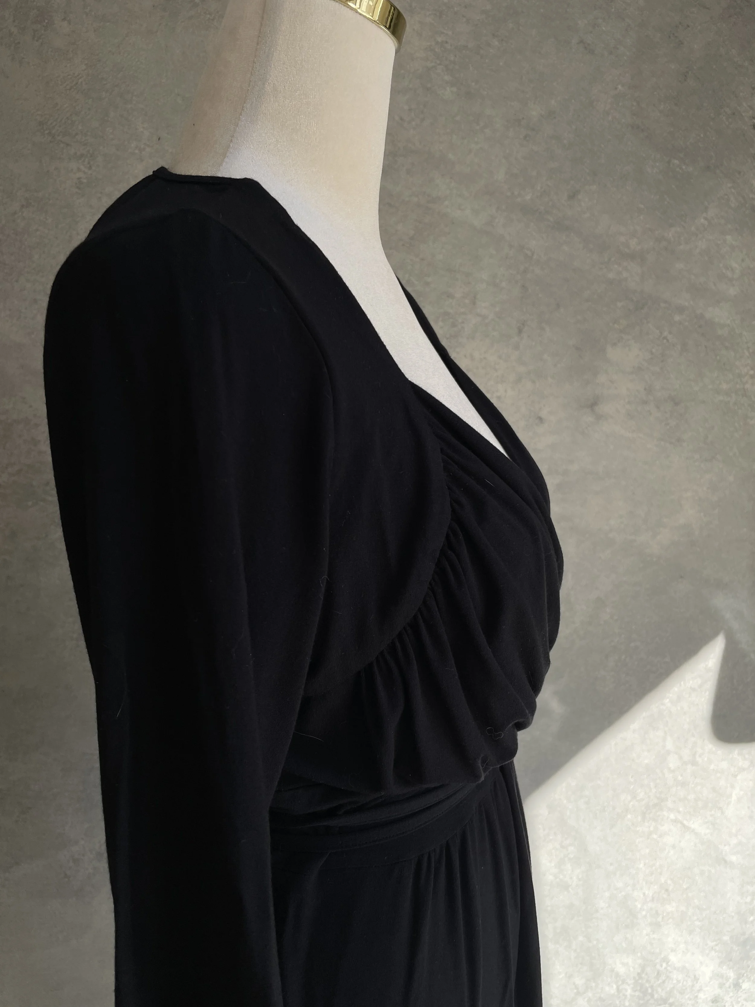 Close-up side view of the draped bodice detail on the black Scapa jersey dress