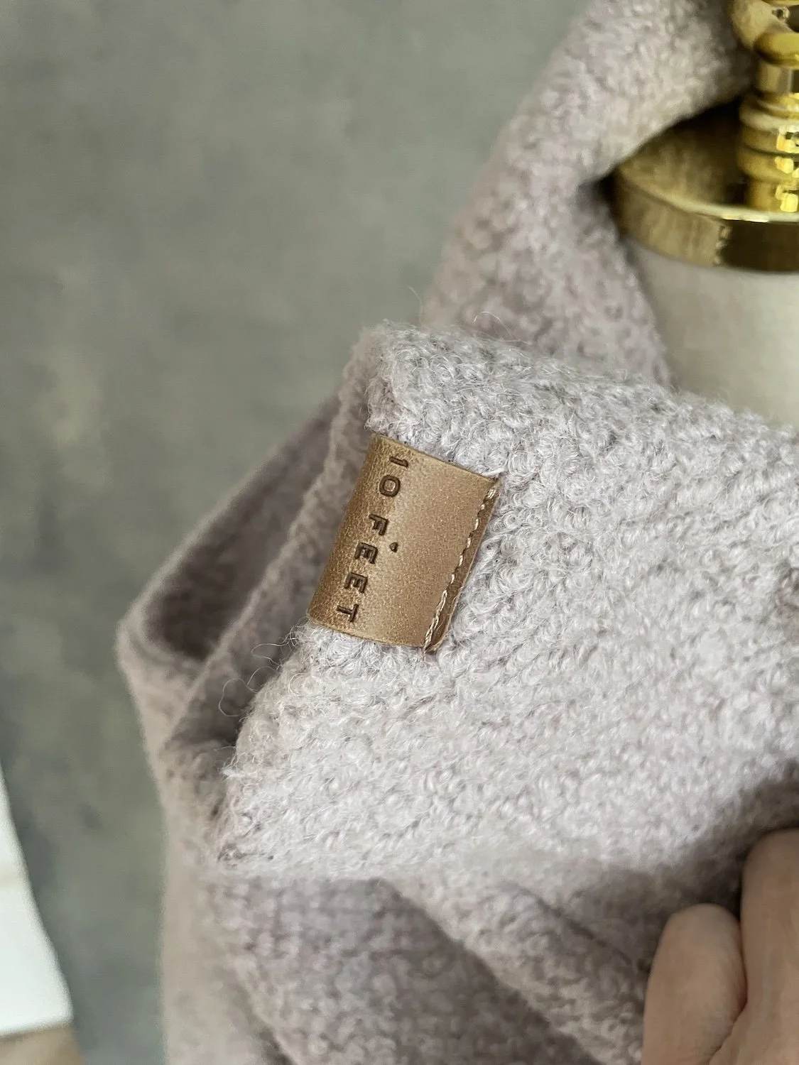 Close-up of the tan leather '10 FEET' brand patch on the collar edge.