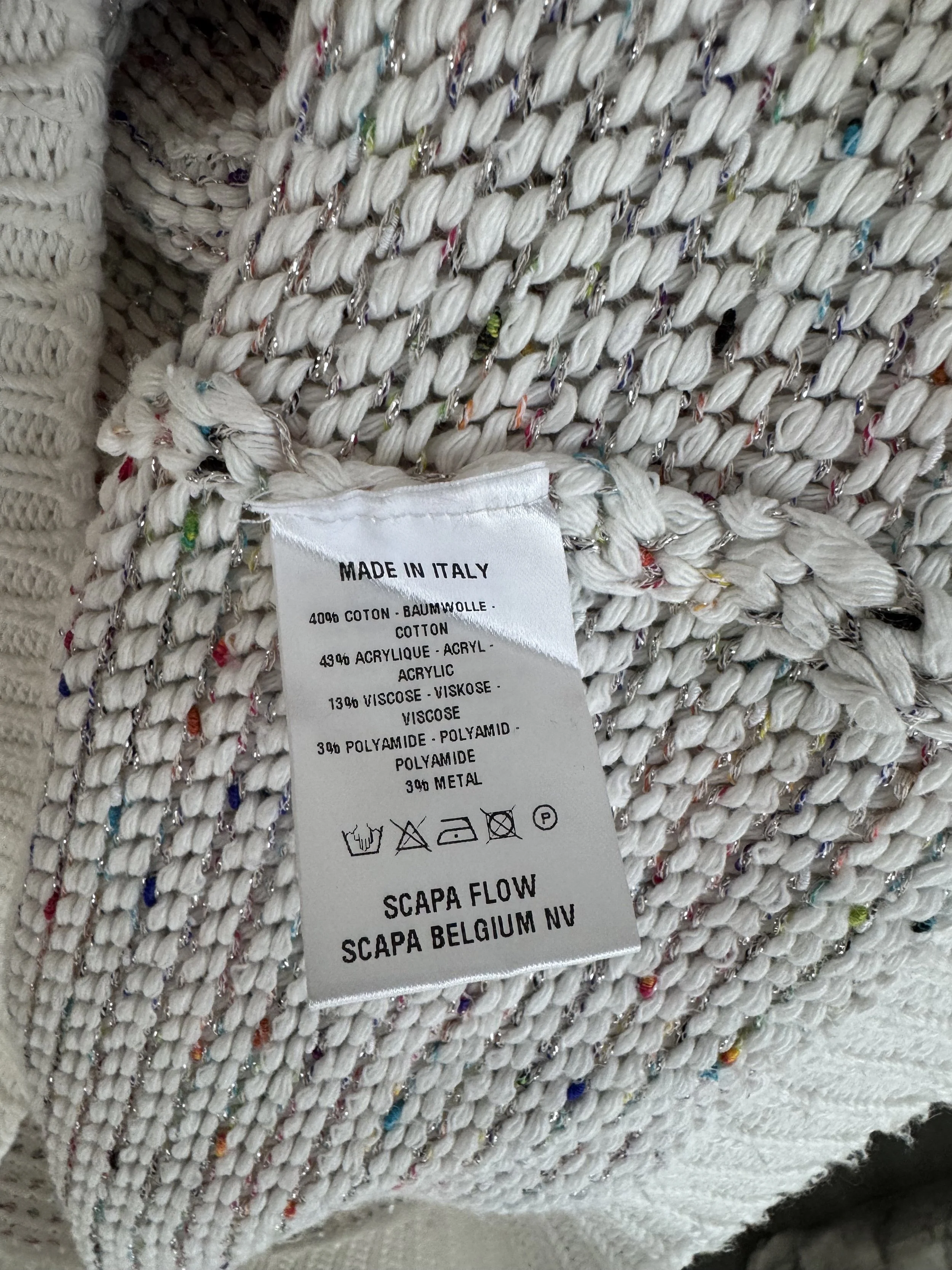 Close-up of the interior care tag detailing the fabric composition including cotton, acrylic, viscose, polyamide, and metal, along with 'MADE IN ITALY'.