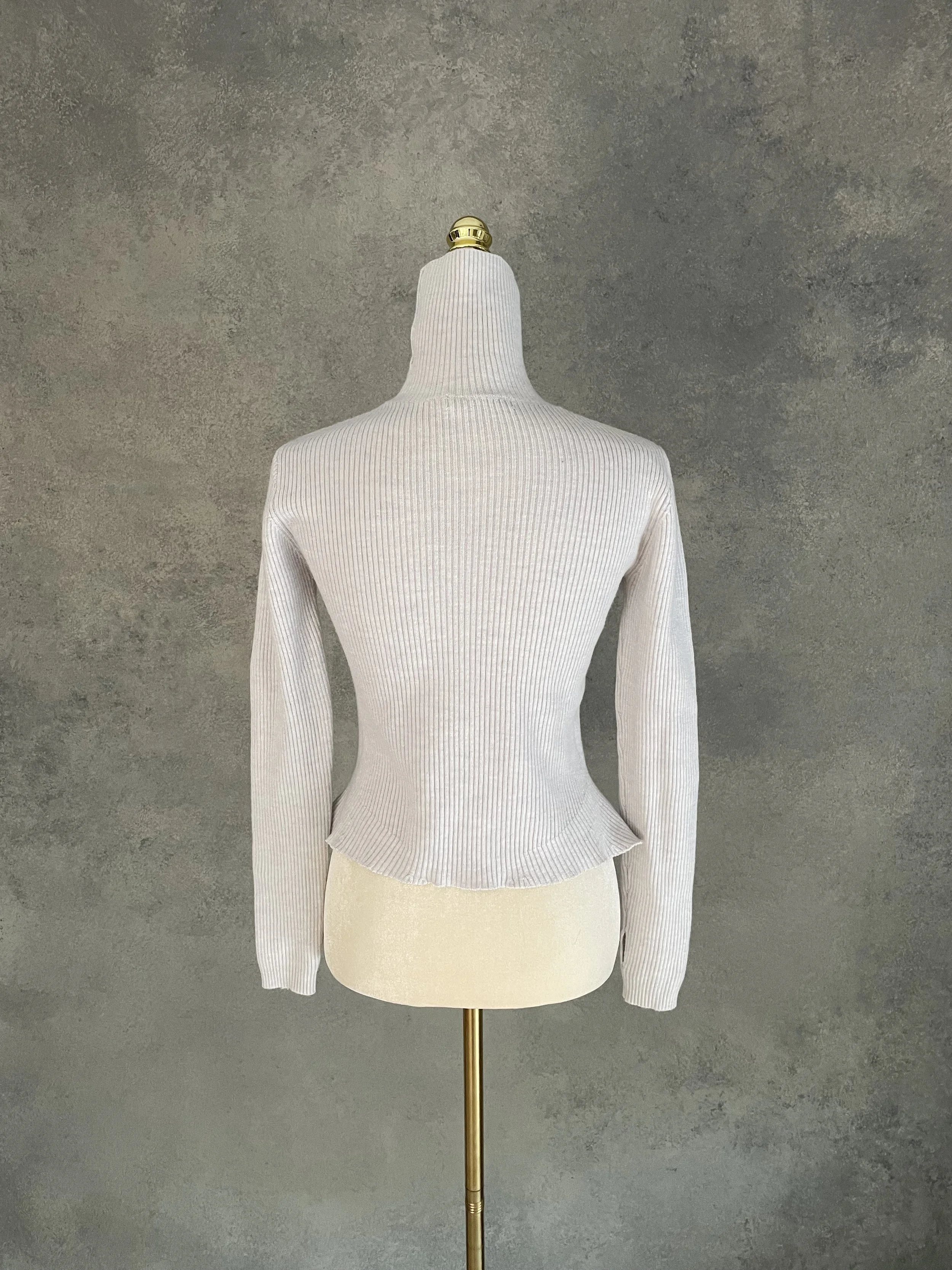 Rear view of the grey Rodebjer ribbed jumper on a mannequin, showcasing the clean, minimalist silhouette.