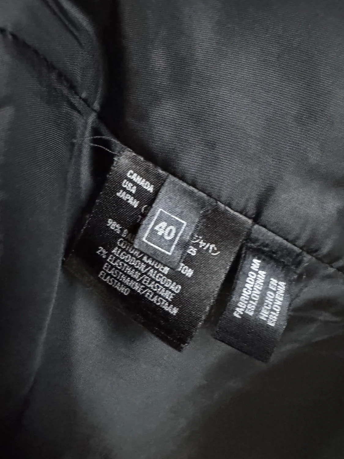 Schwarz gedrucktes Pflegeetikett der Laurèl Jacke mit Größenangabe 40 und Materialzusammensetzung 98% Baumwolle, 2% Elasthan