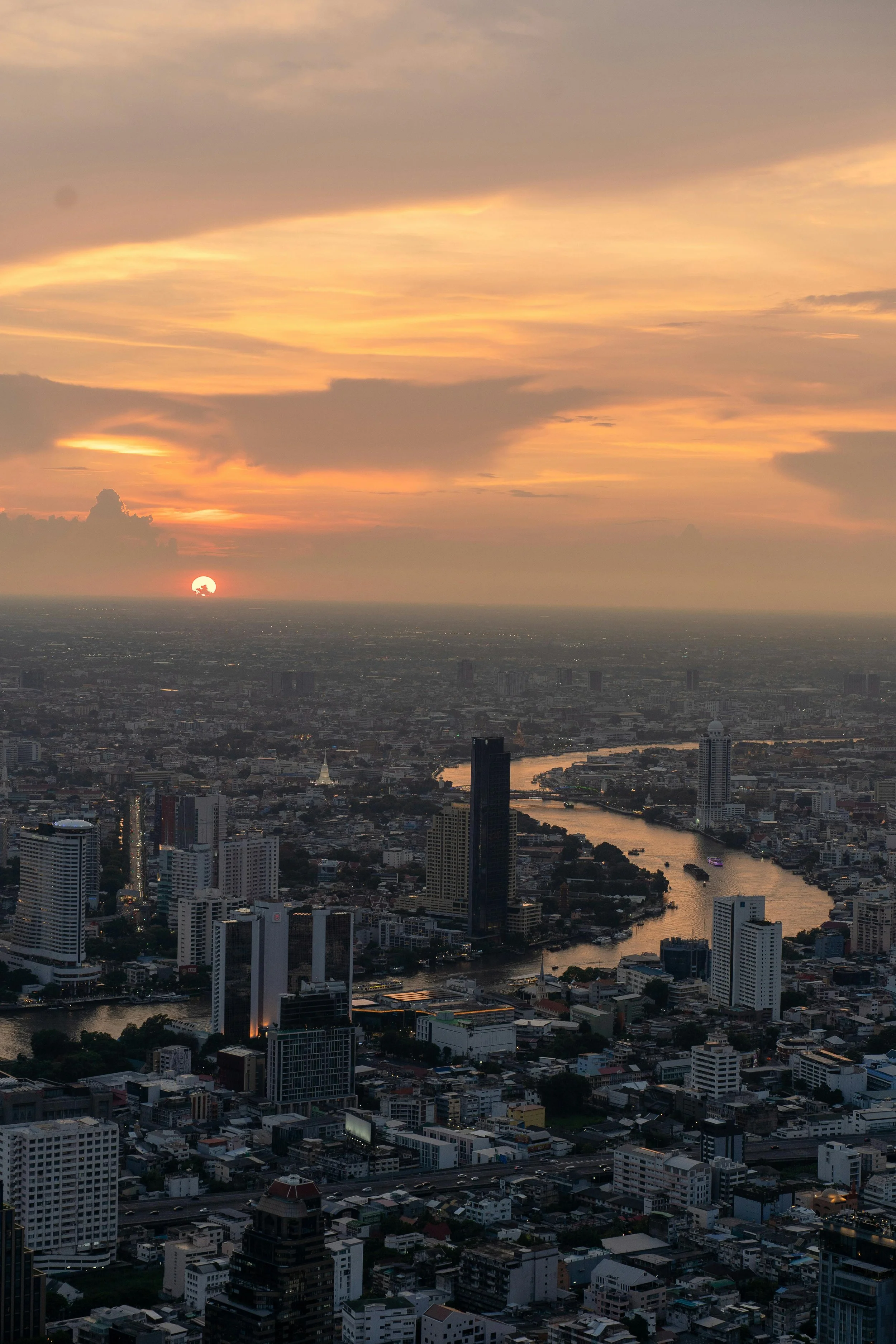 Bangkok condominiums and cityscape at dusk with a view of the Chao Phraya River