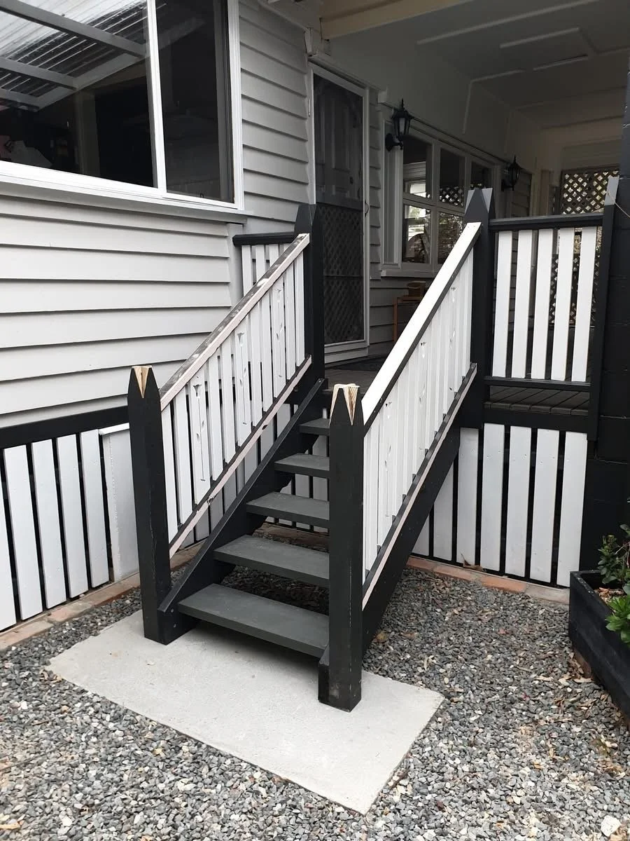 external veranda stair case, concrete slab, gravel ground covering.