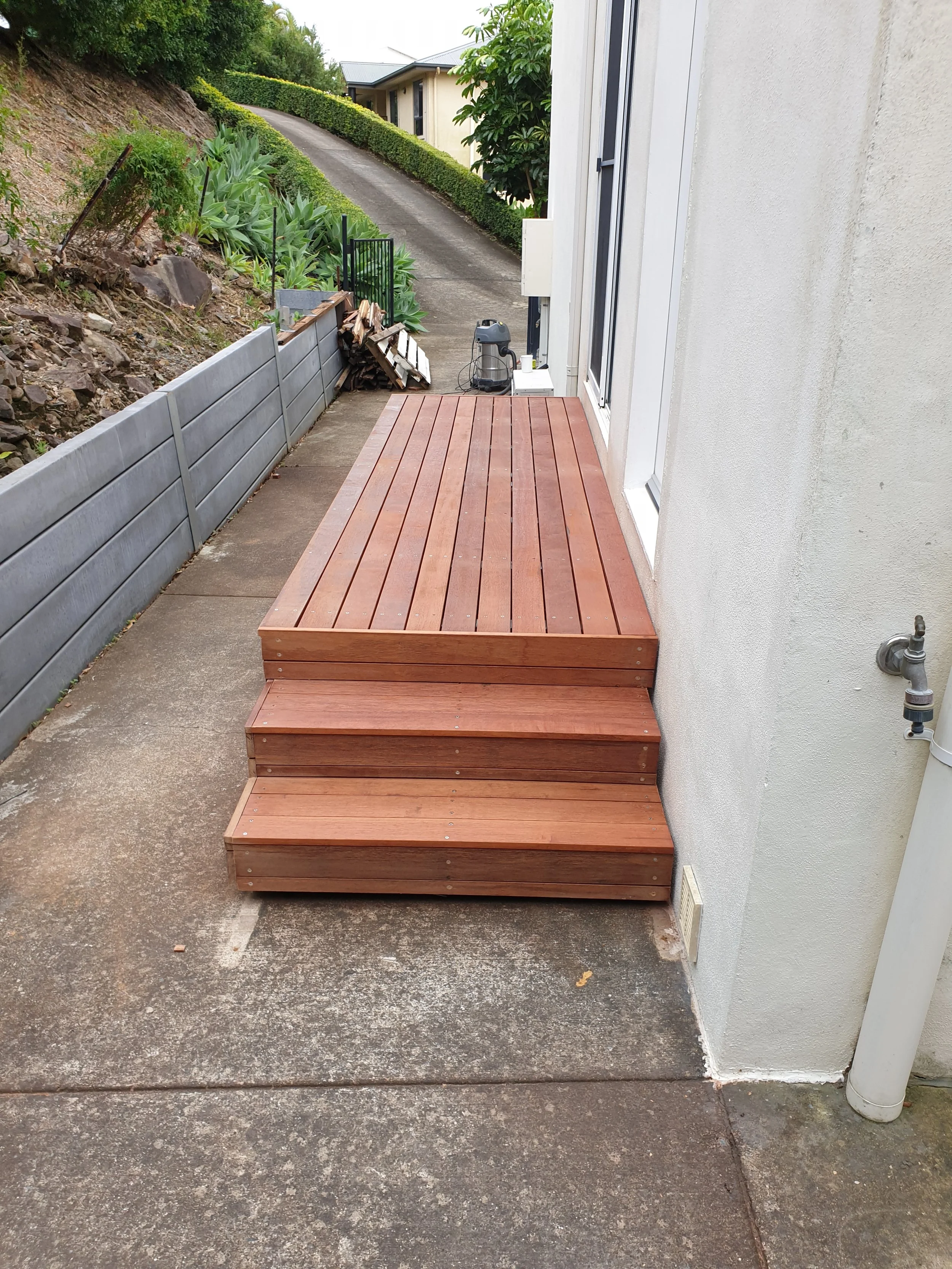Wooden deck, oil stained, external side entrance.