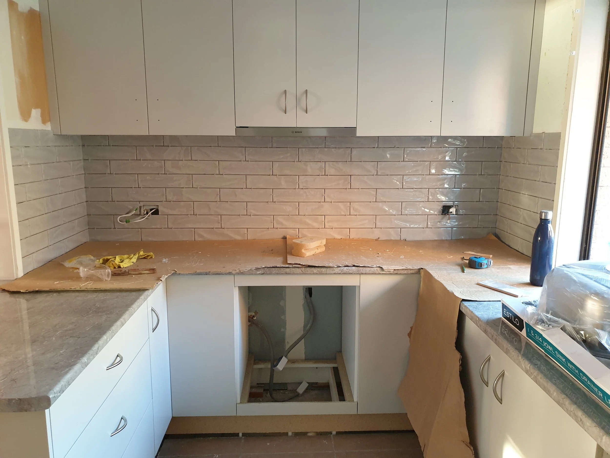 kitchen with white subway tiles being installed.