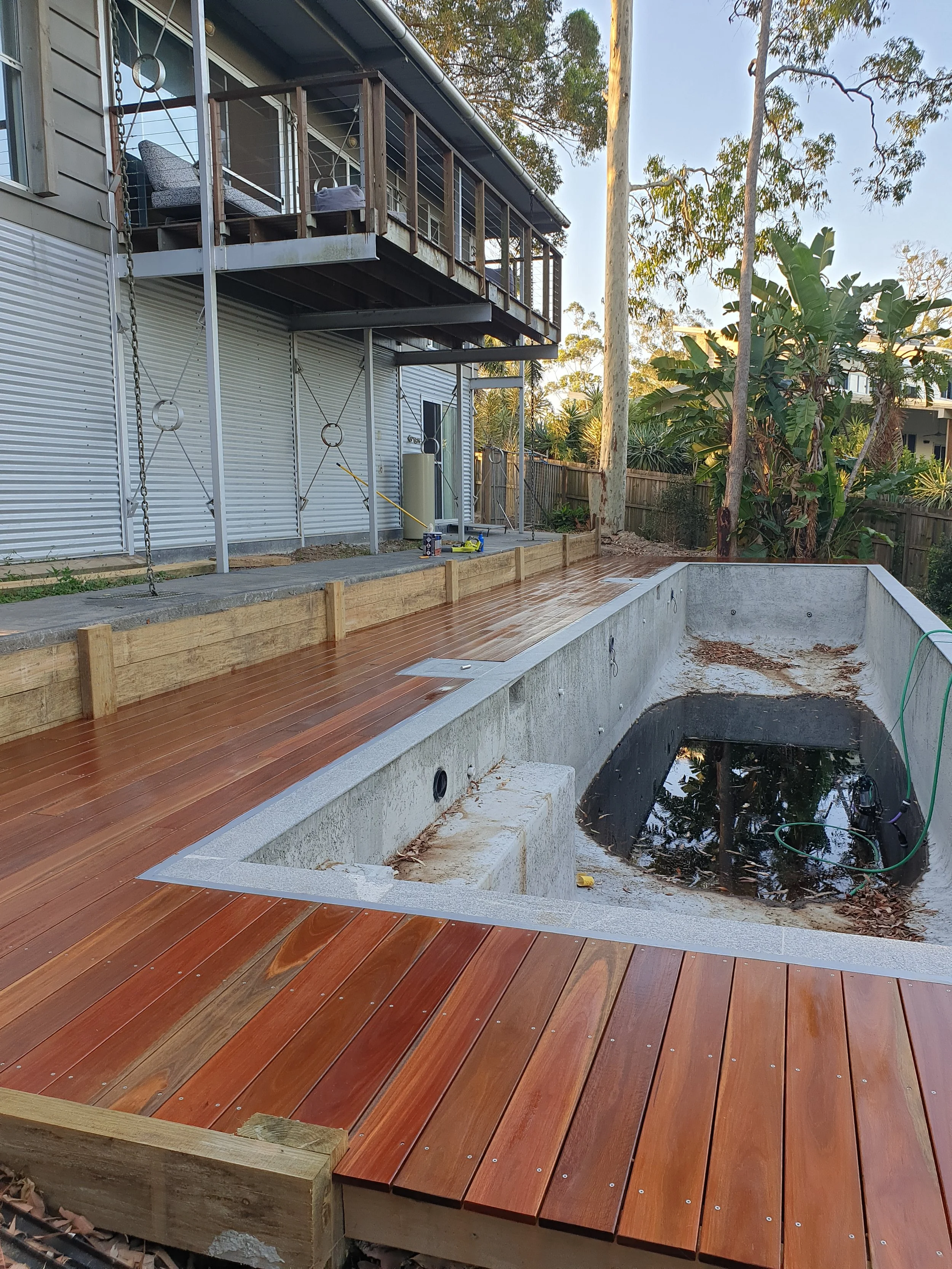 Stained timber, Merbau decking around small swimming pool.