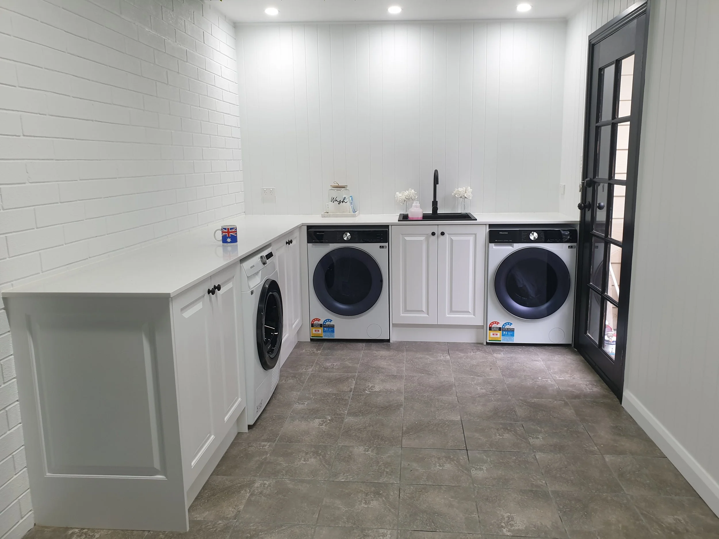 Laundry, white bench tops, white paint, white cabinetry, flooring.