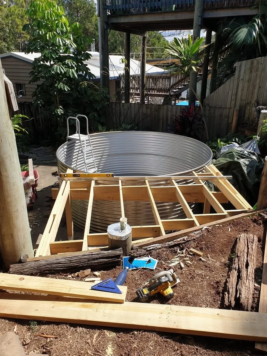 Water tank styled swimming pool with timber deck preparations.