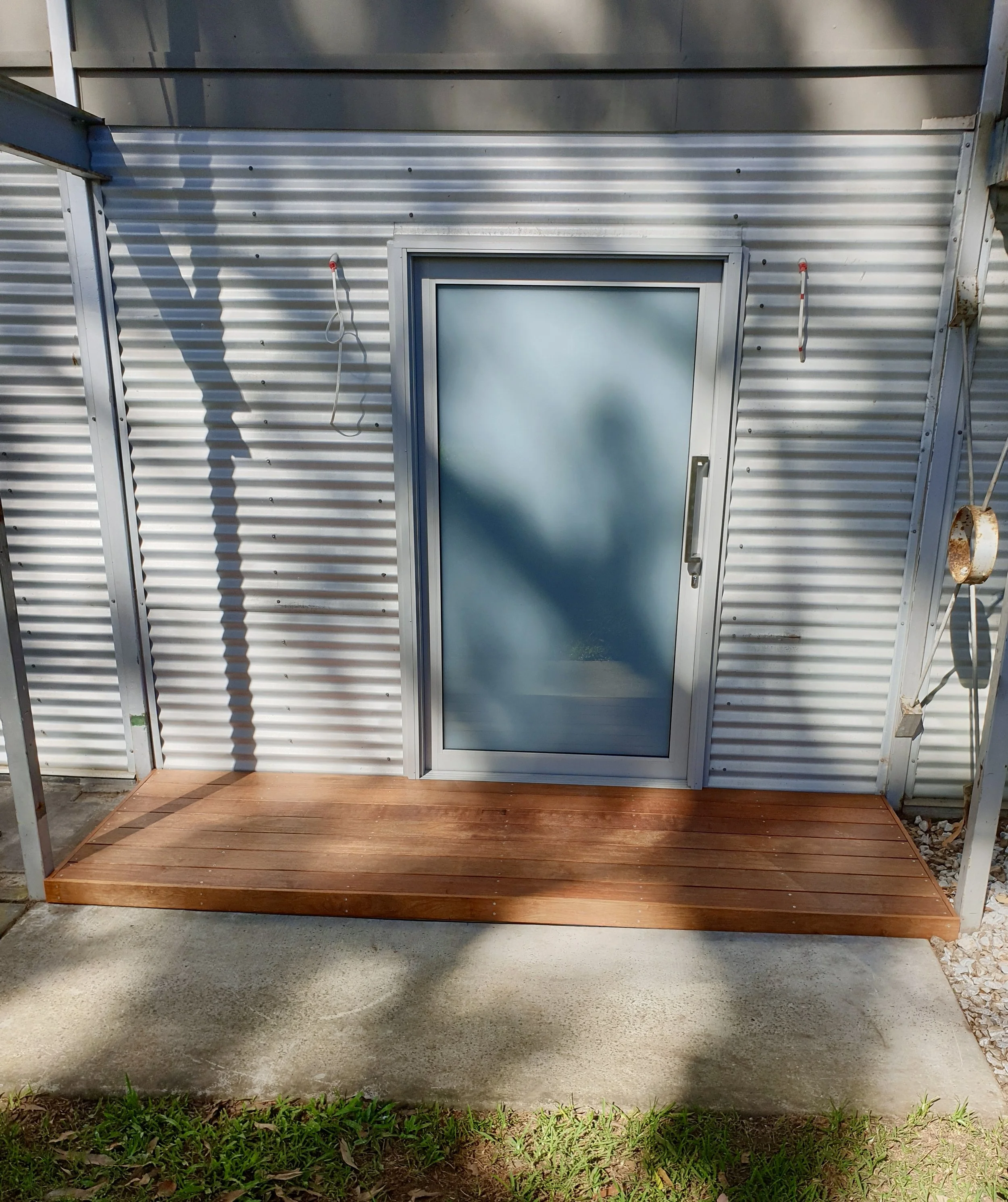 entrance to house, wooden timber step, corrugated iron walls.