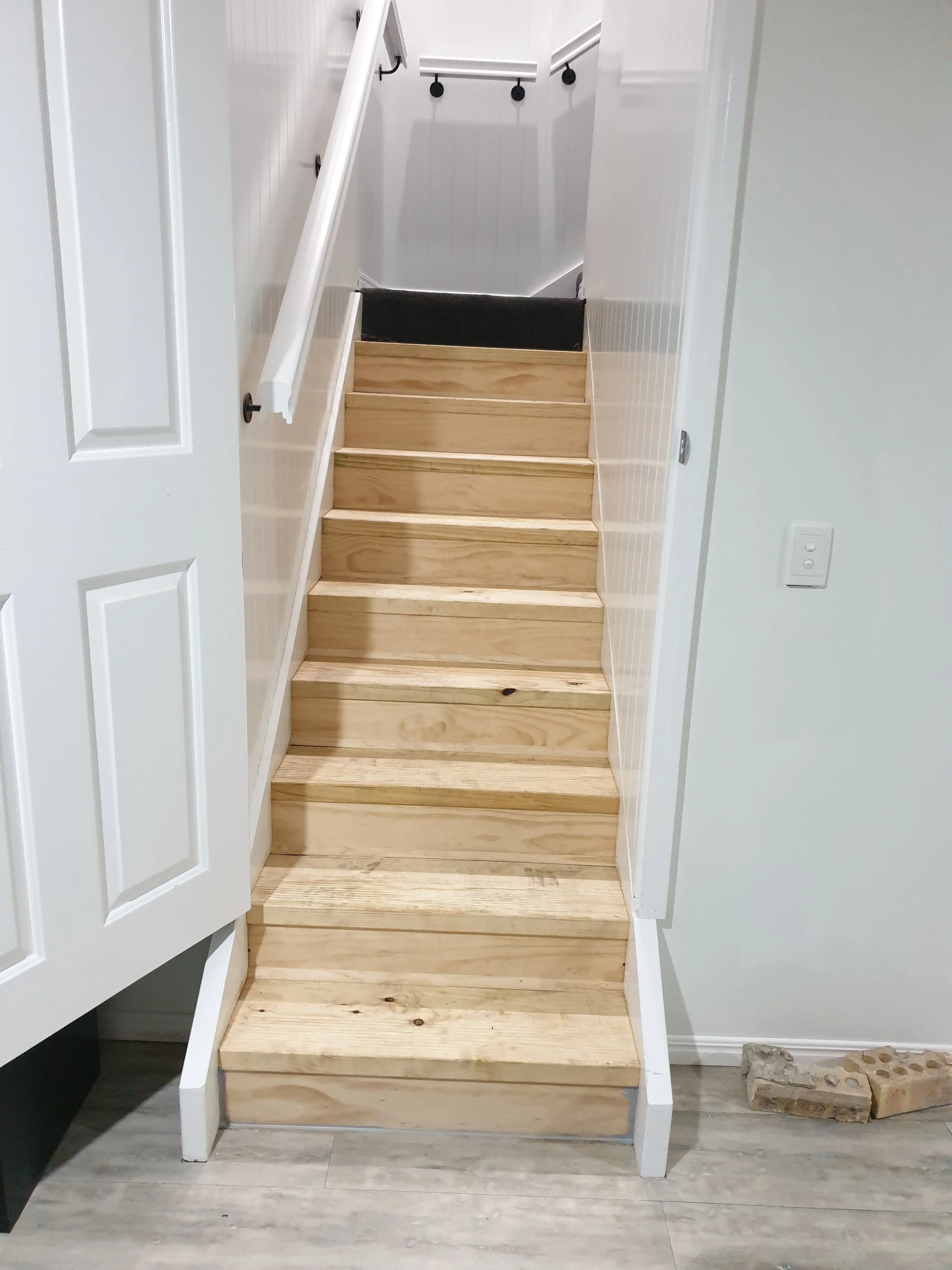 Internal staircase, white walls, timber steps.