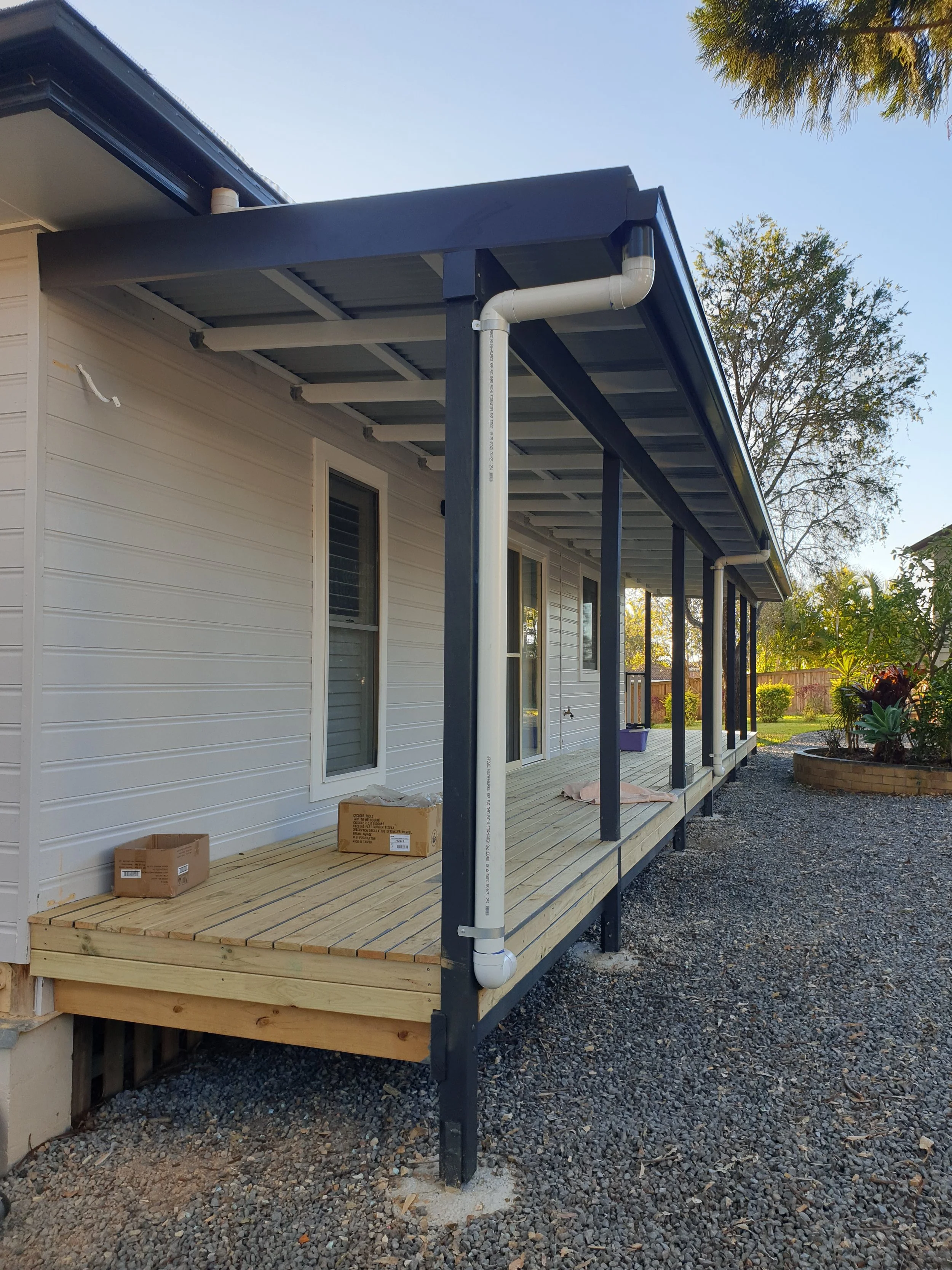 House with wooden deck and corrugated iron roofing. 