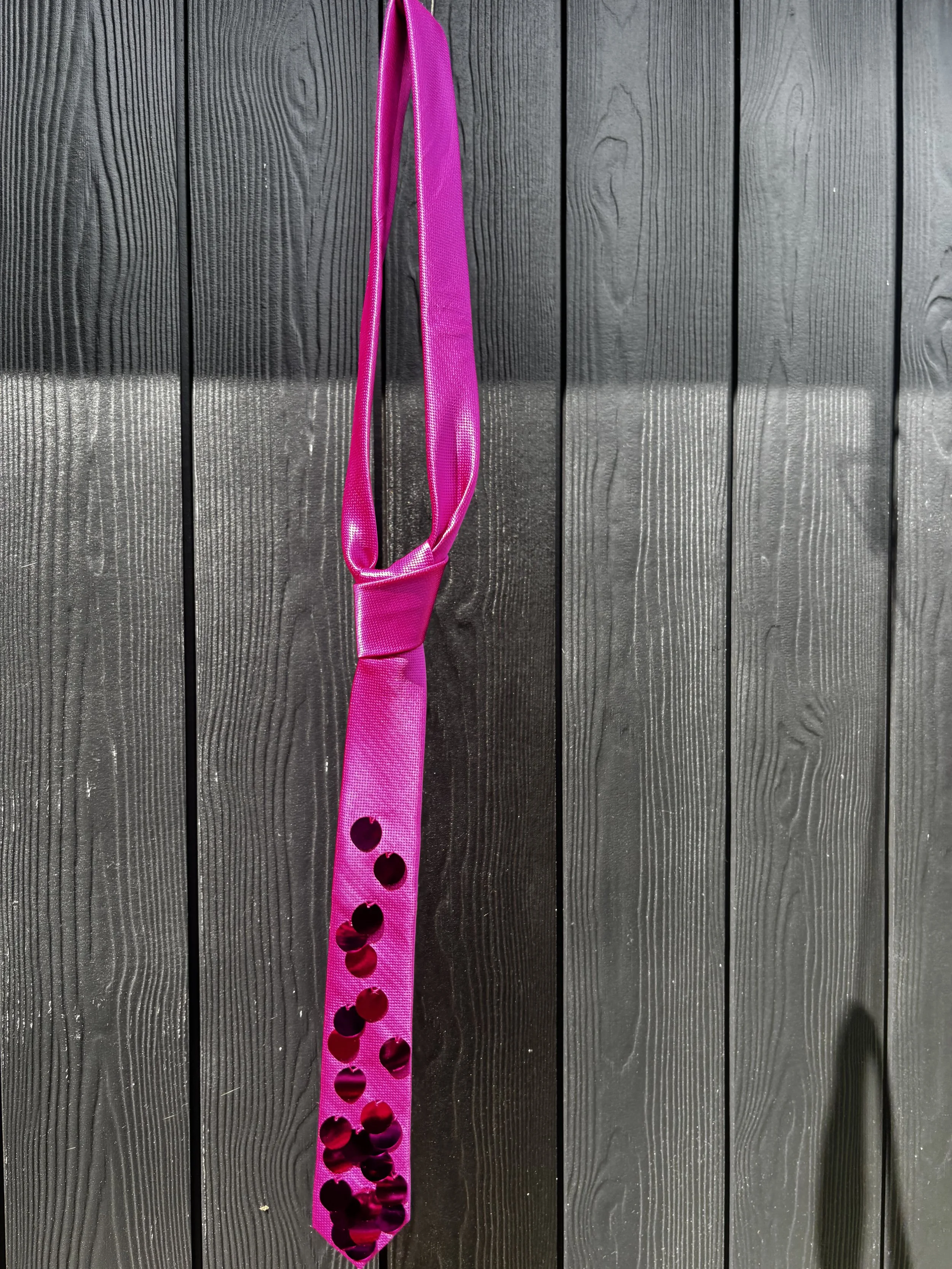 A slim pink tie with pink sequins .