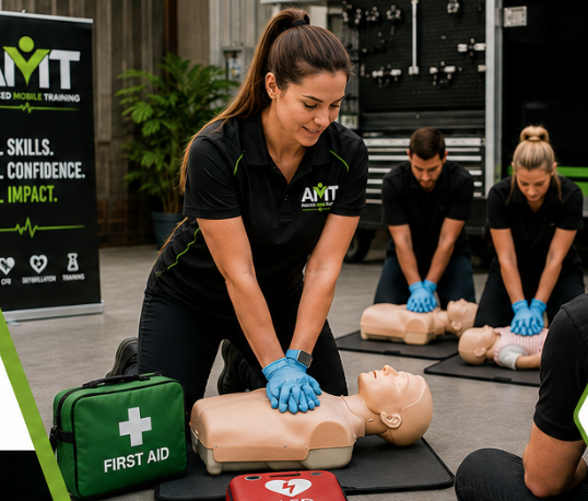 Woman practicing CPR on mannequin during First Aid training session at AMIT. Others in background practicing on mannequins.