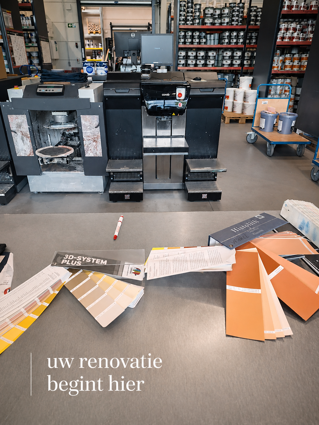 Fotografie van een werkplek met verf- en schildermaterialen, meetstalen en verfverpakken, en een kopieer- of printersysteem op een werktafel. De tekst op de foto zegt 'uw renovatie begint hier'.