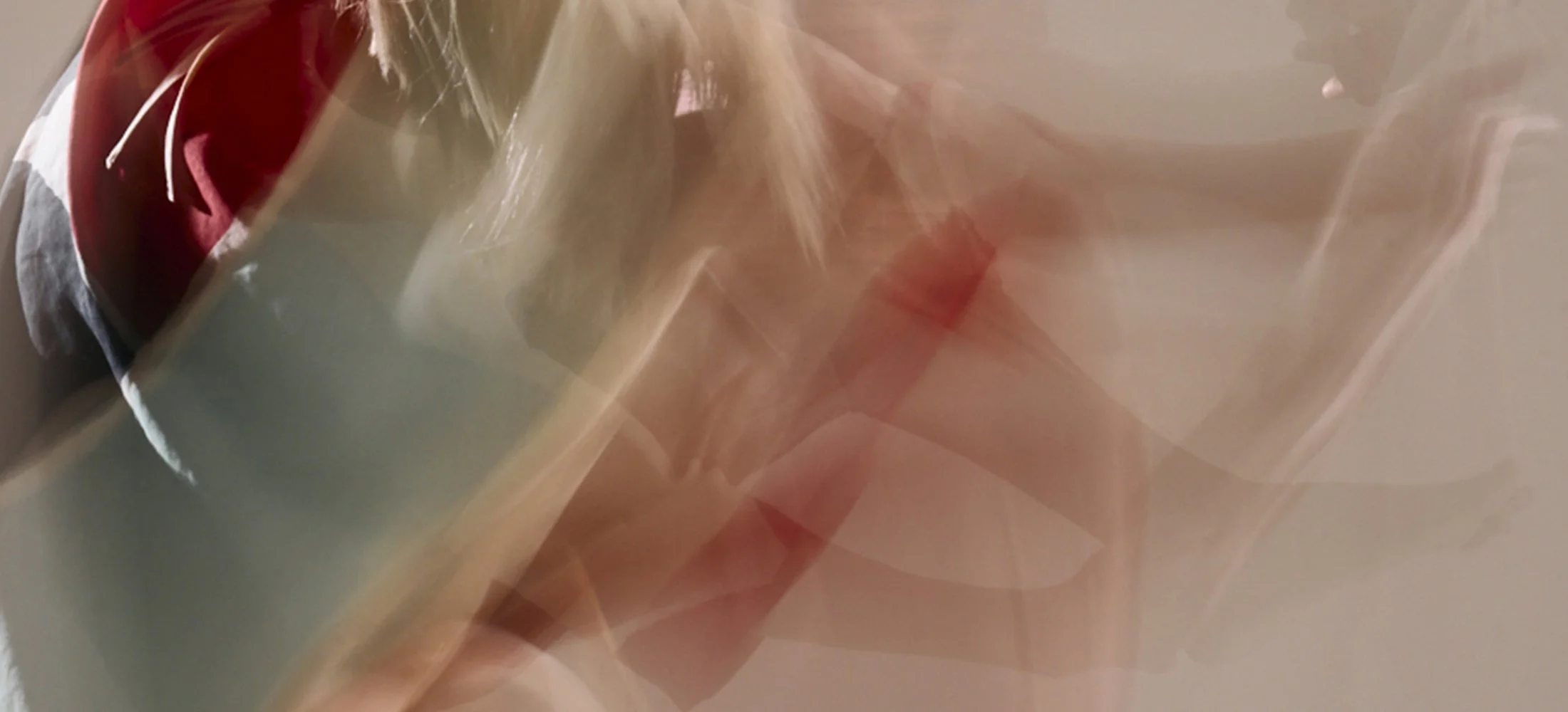 Abstract blurred movement in shades of beige, red, coral, pink and grey.