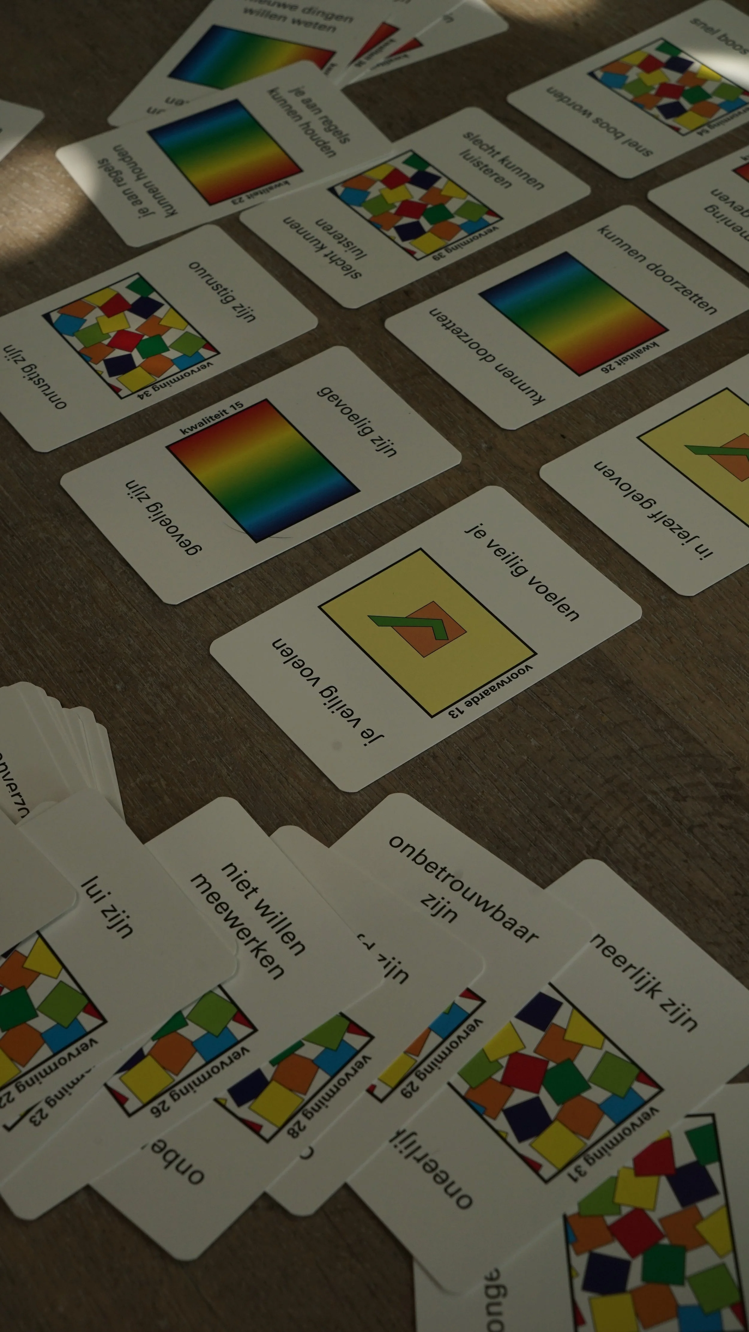 Verdeelkaarten met kleuren en teksten in het Nederlands, gerelateerd aan woorden en eigenschappen.