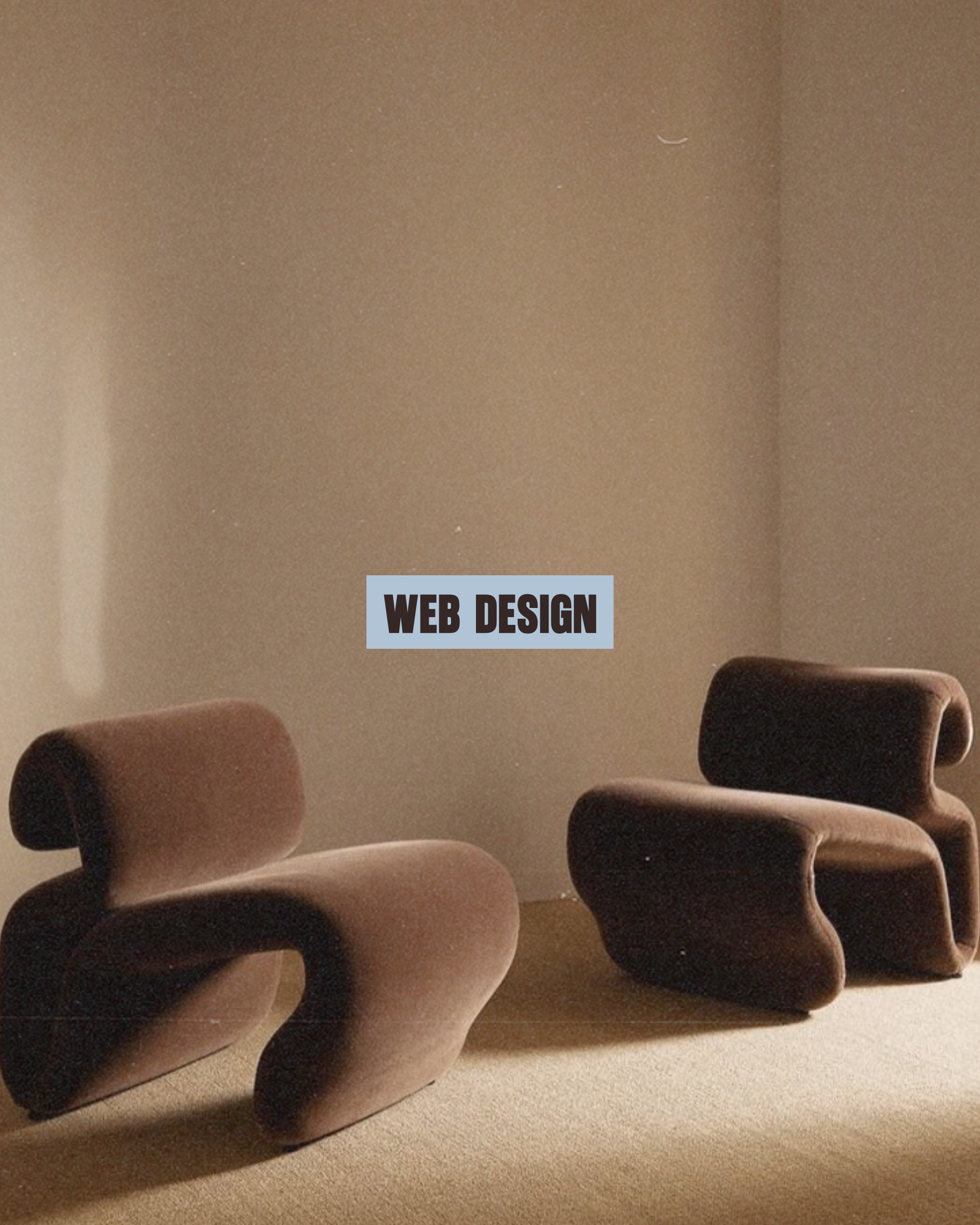 A hand resting on a beige surface with several rolled-up socks in varying shades of brown and gray. In the background, a wall with a sign that reads 'WEB DESIGN' is visible.