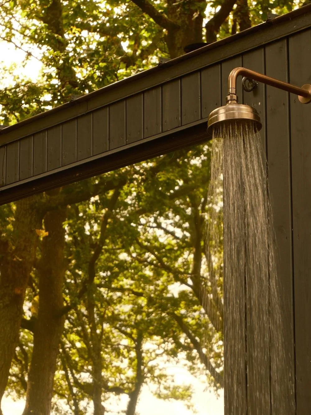 outdoor shower mounted on a wooden sauna hut