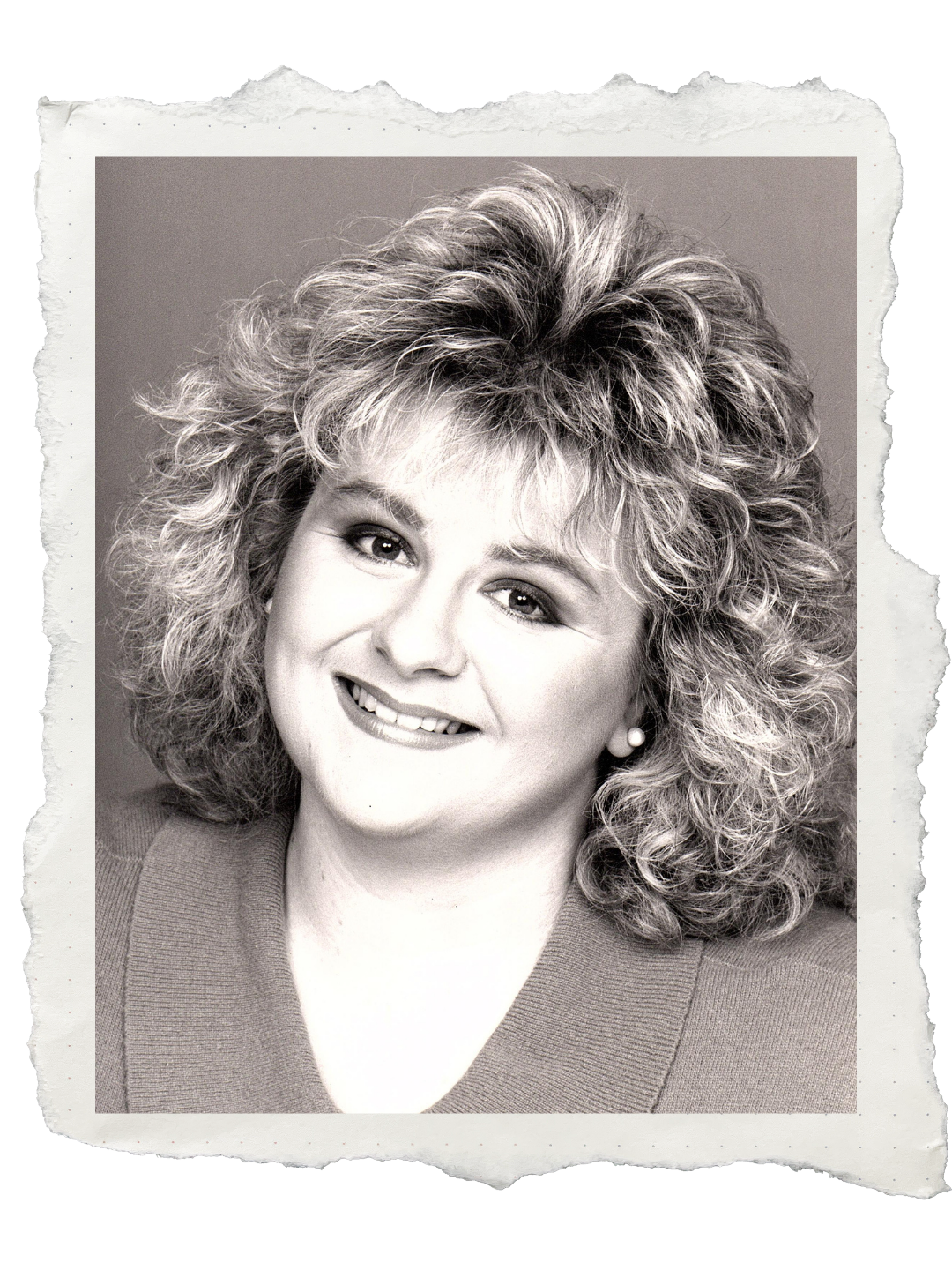 Sara Ford Black and white portrait of a woman with curly hair, smiling, wearing earrings and a top.