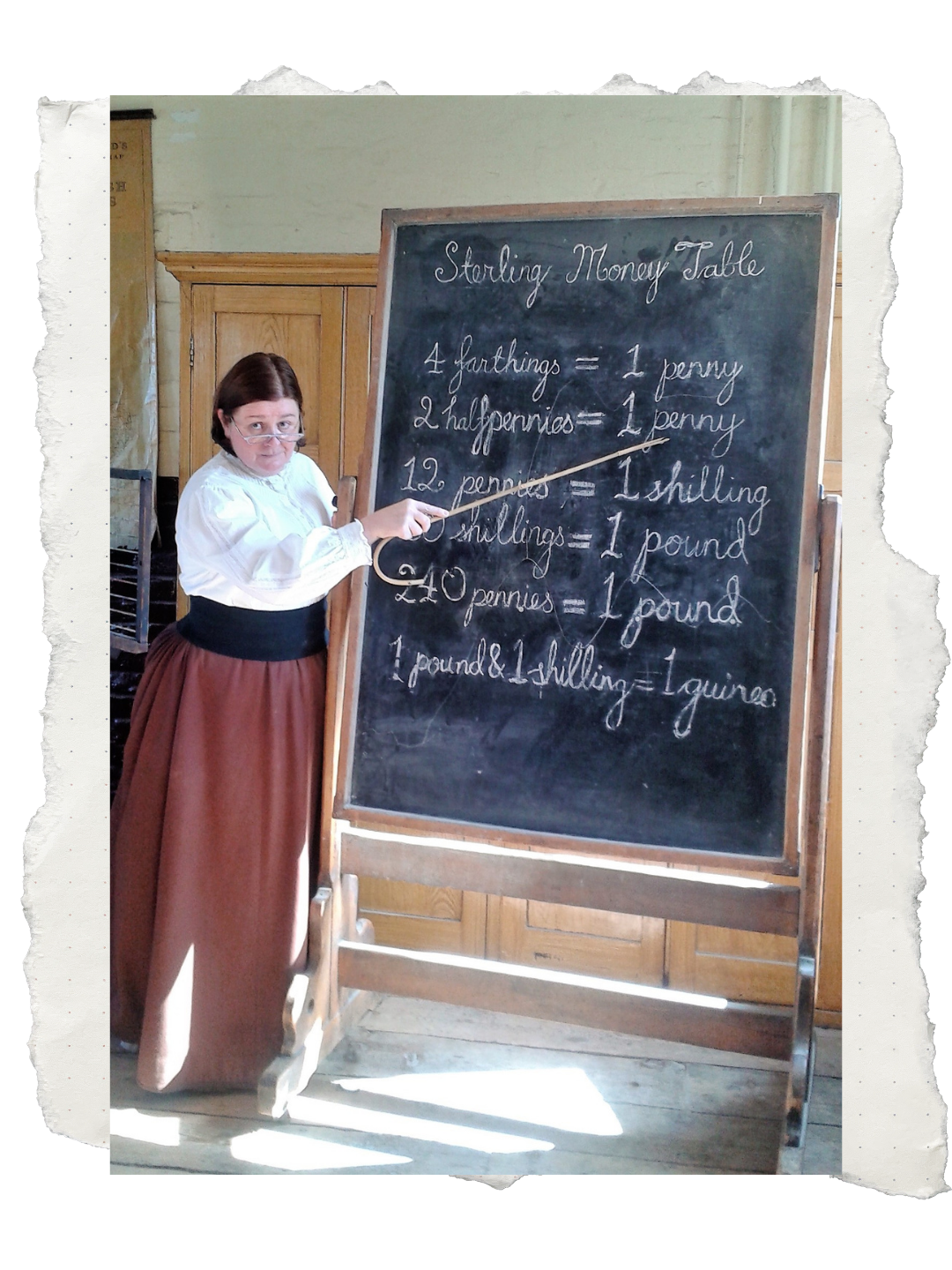 Sara Ford Woman in historical clothing pointing at a chalkboard with a list of old currency conversions written on it.