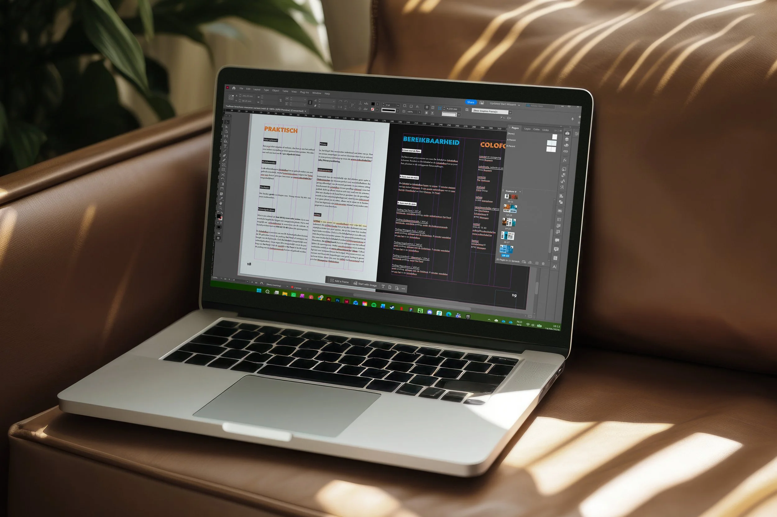 Een open MacBook op een houten tafel, waarop een ontwerpprogramma met documenten en grafische ontwerpen te zien is. In de achtergrond een bank en groene planten.