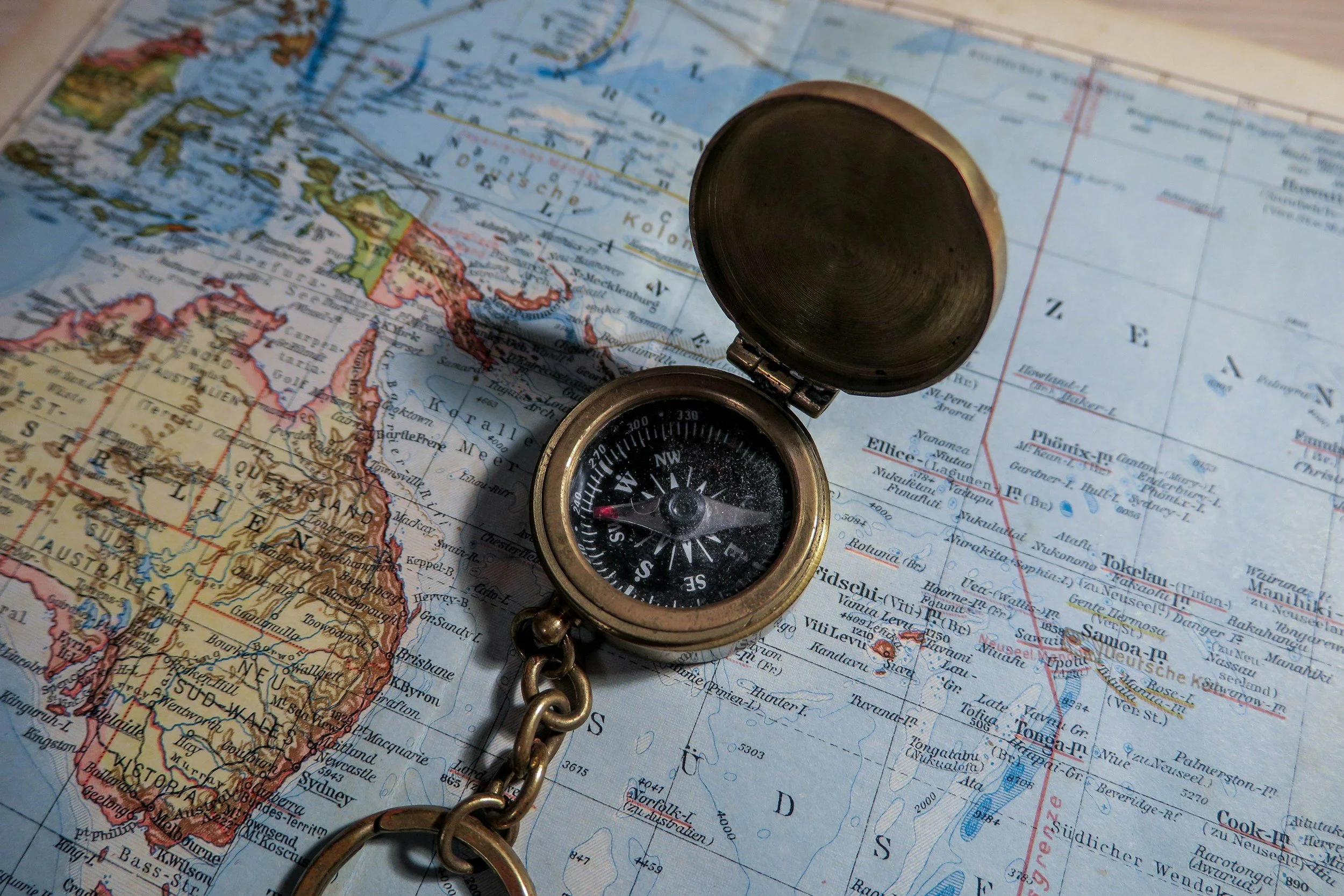 Ein Kompass liegt auf einer Weltkarte, die Australien und den Nahen Osten zeigt.
