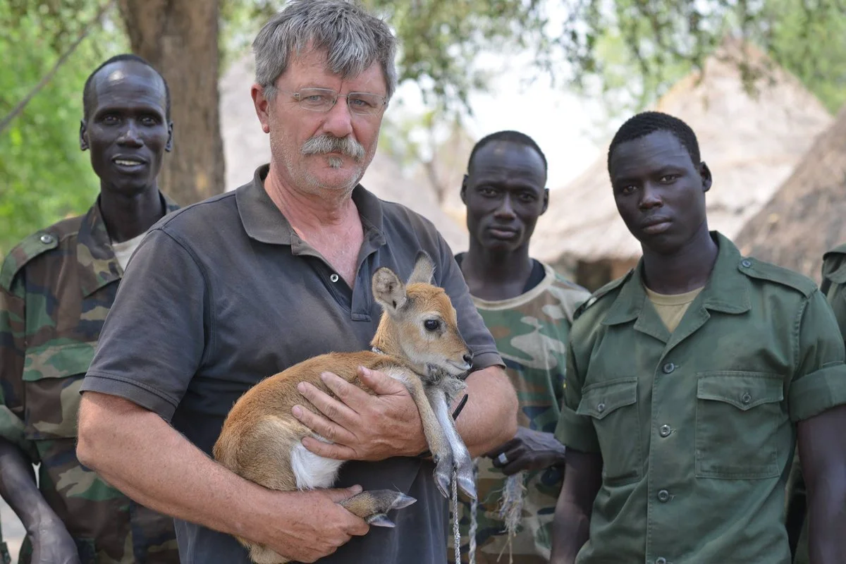 Robert Young Pelton holding a young antelope surrounded by four Nuer fighters in Akobo, South Sudan. A gift that I couldn't bring myself to eat. ©RYP, all rights reserved