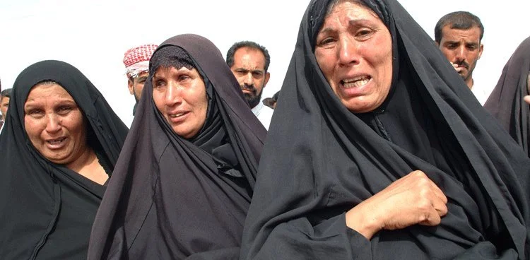 May 2003. In al-Mahawil, Iraq Shia women wait as bodies are exhumed by backhoe from a mass grave from 1991.  @RYP all rights reserved