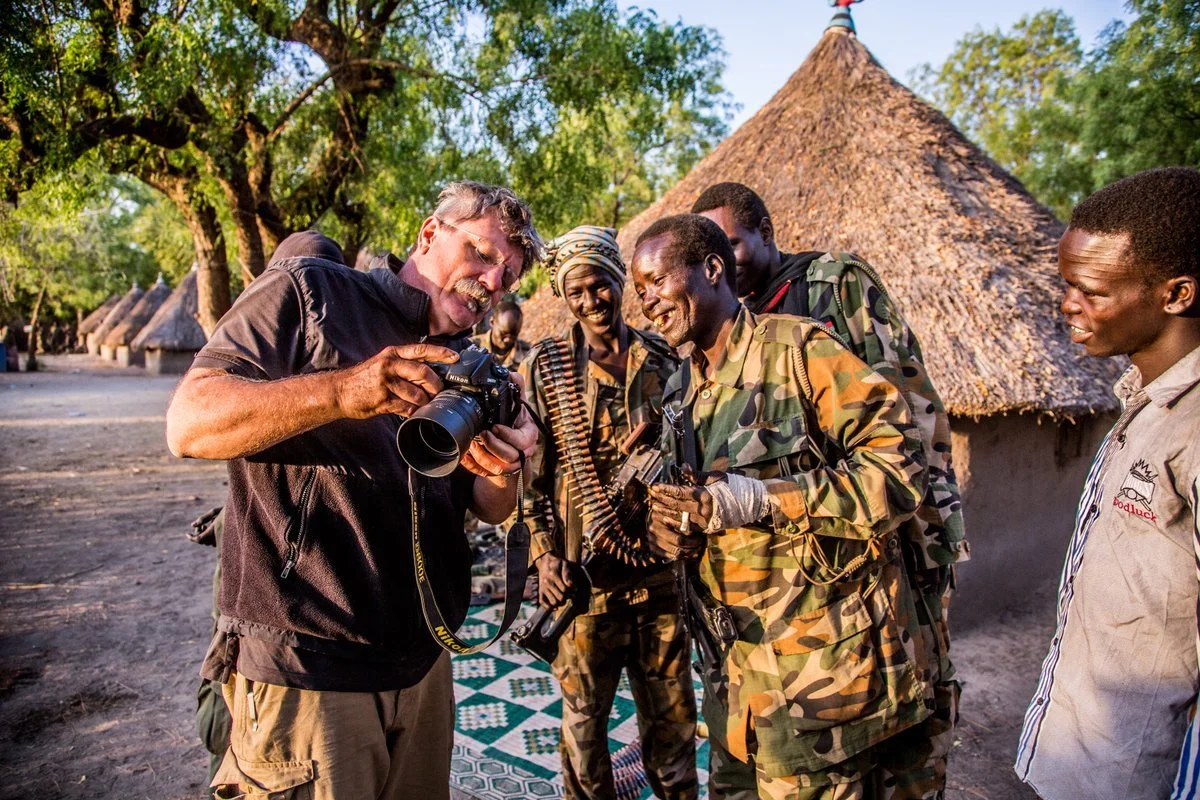 Robert Young Pelton shows Nuer fighters in South Sudan their portraits.  ©Robert Young Pelton. all rights reserved. 