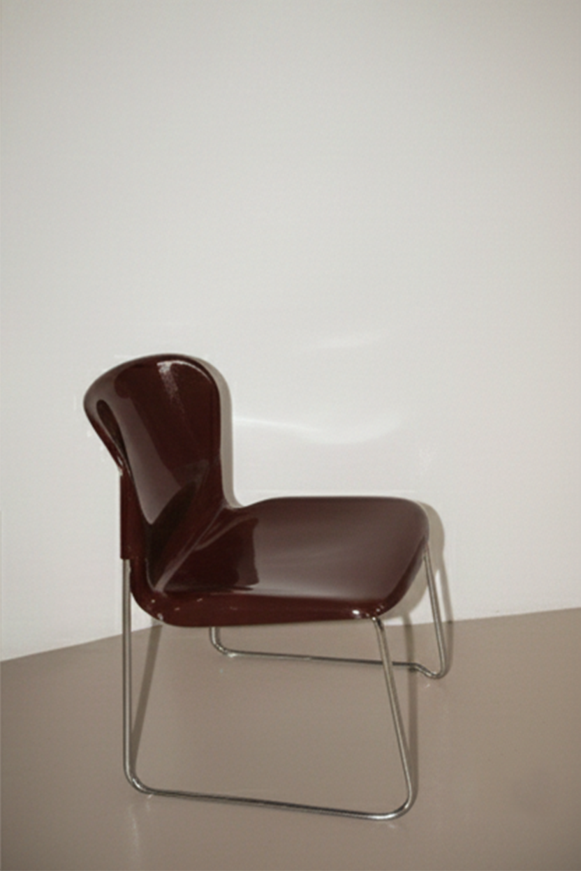 A modern chair with a dark brown, glossy plastic seat and backrest, supported by silver metal legs, placed against a plain white wall.