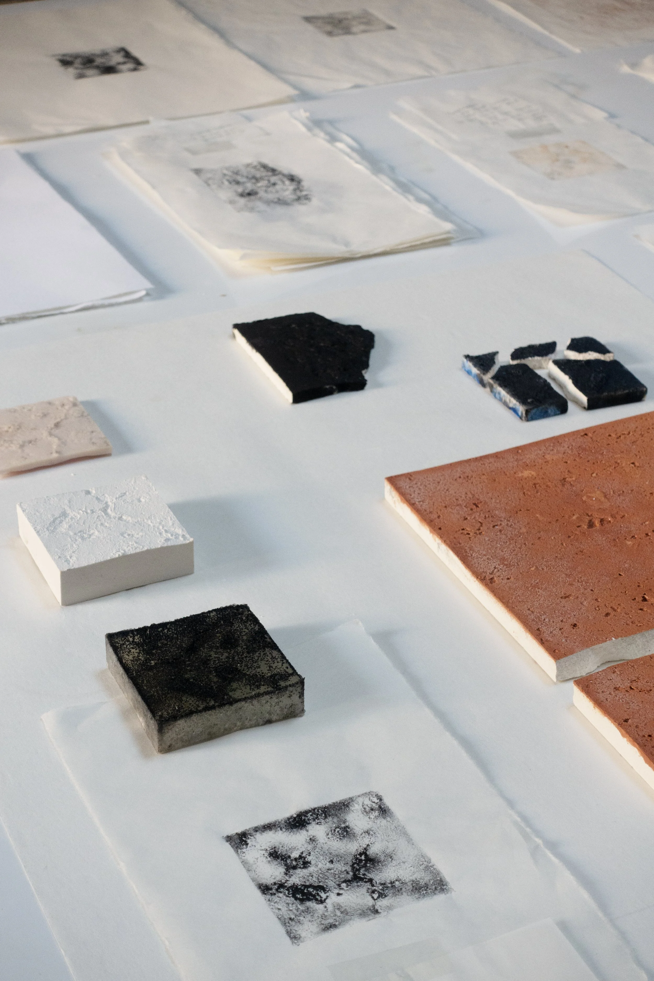 Our working table at The Danish Institute in Rome, with casts, prints and paper tests. 
Graphic printing ink on Japanese paper, silicone, and plaster, approximately 20 × 30 cm, 2022 