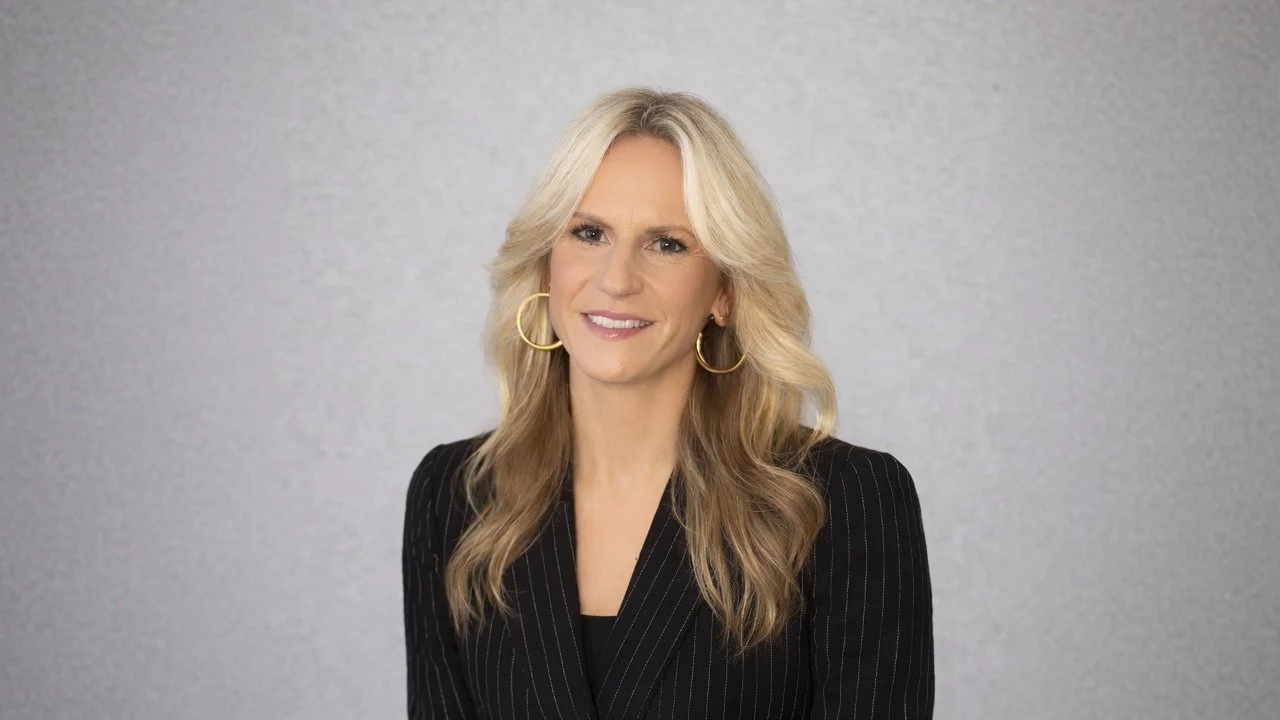 Anne Delp business woman portrait in stripey black suit.