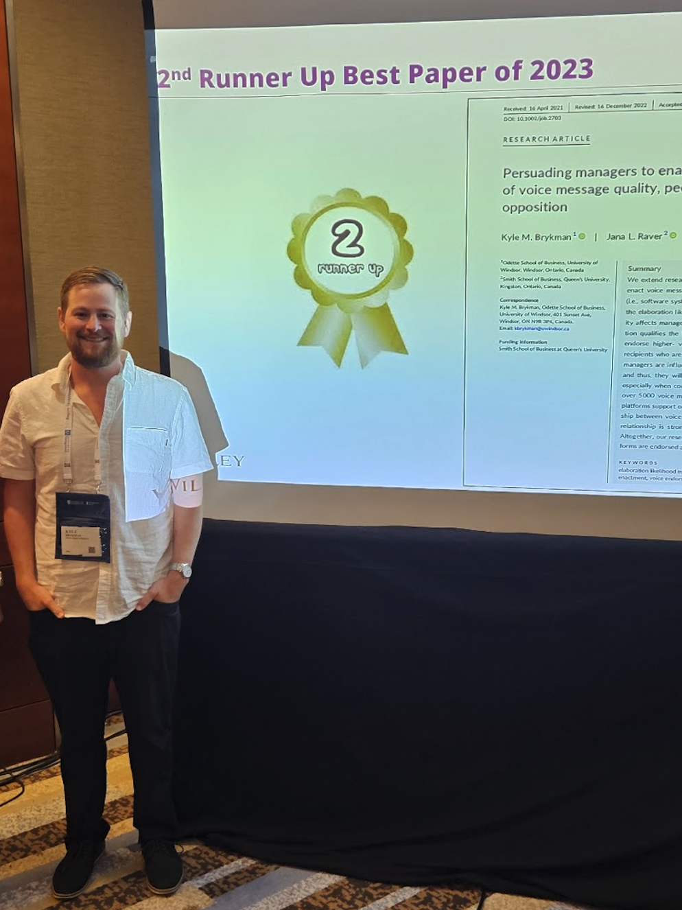Kyle Brykman accepting a 2nd Runner Up Best Paper award at an academic conference