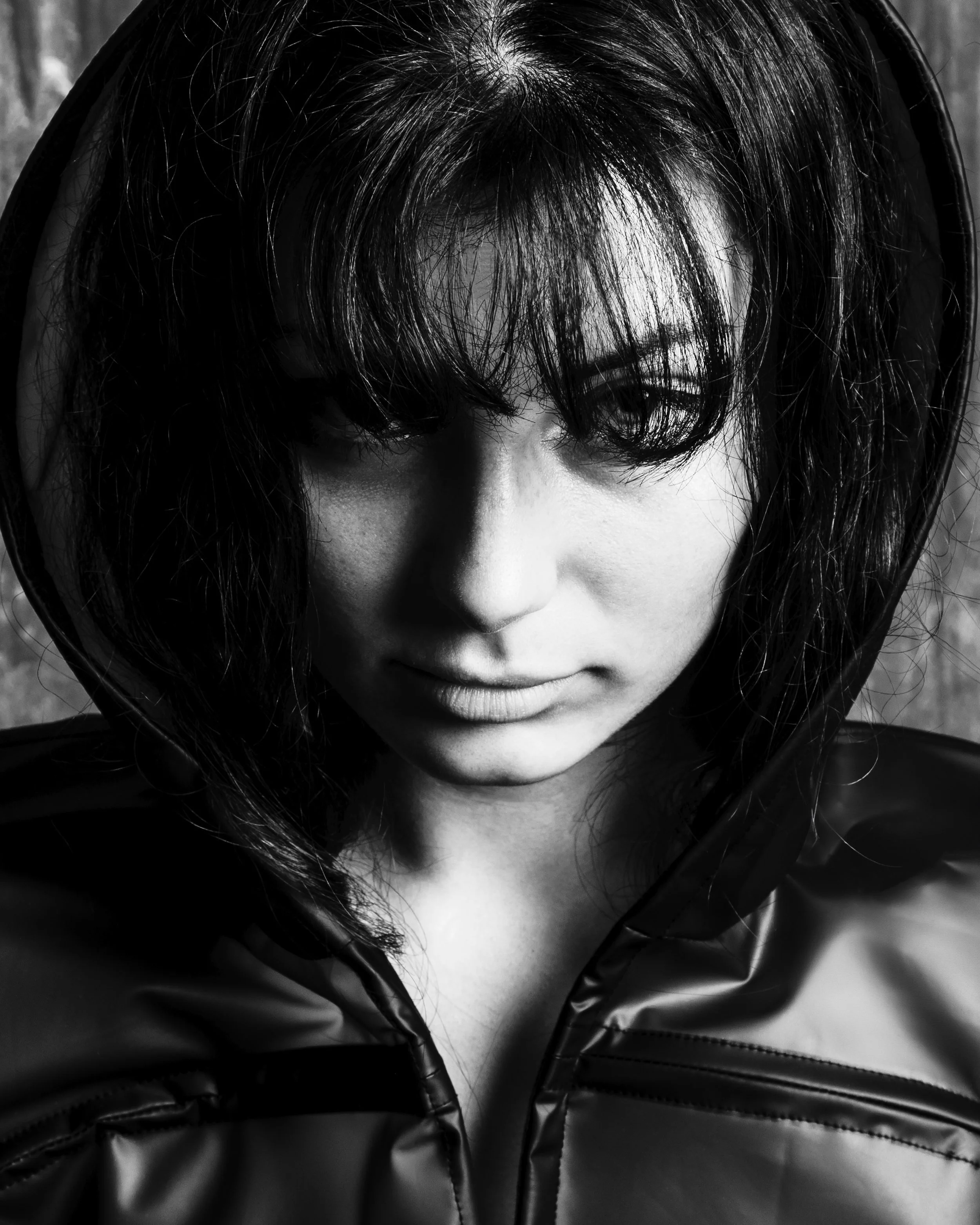 Un portrait en noir et blanc d'une femme avec des cheveux noir, portant une veste en cuir.