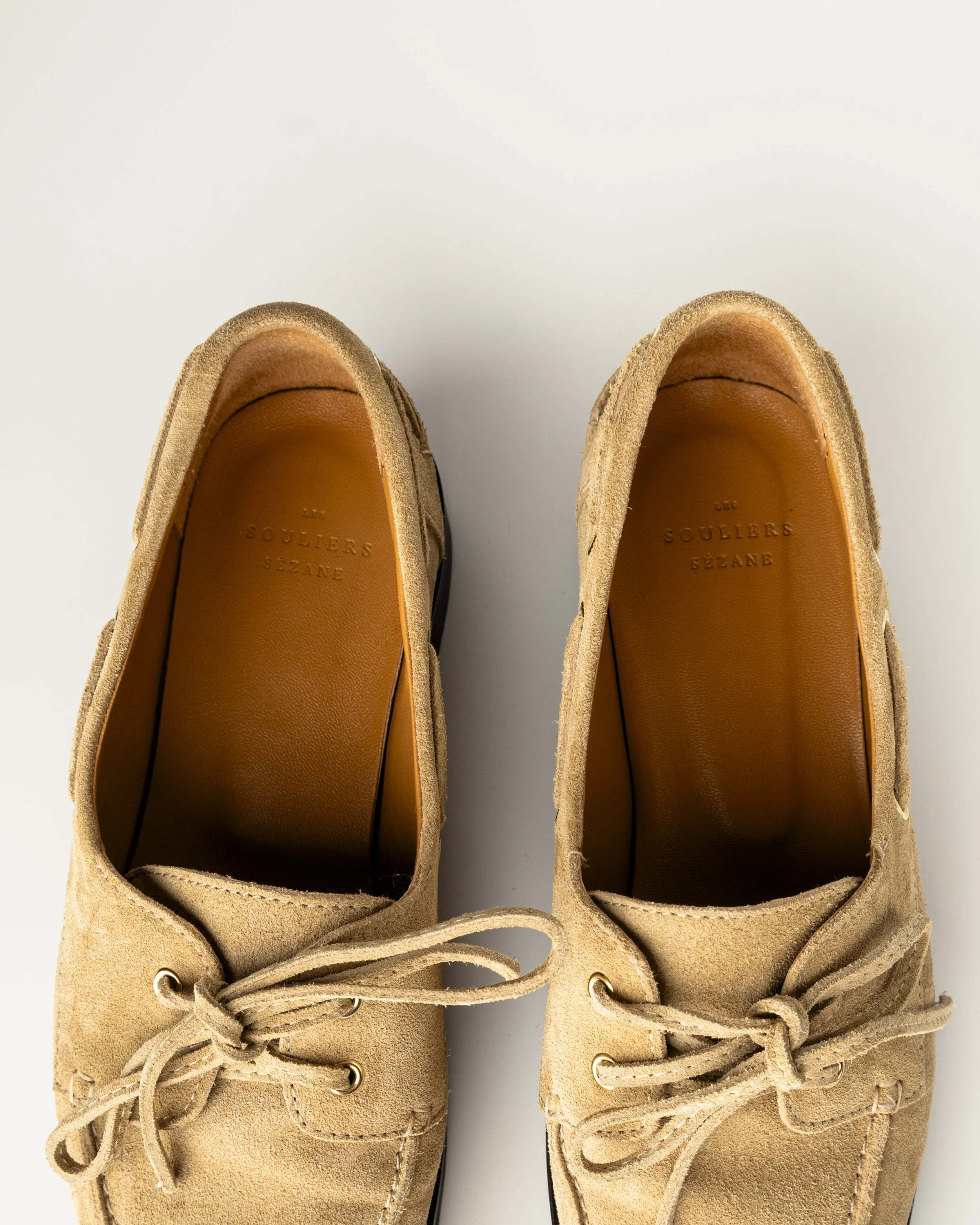 Chaussures en daim beige avec lacets, vues du dessus, avec la marque 'Les Souliers Sezane' à l'intérieur.