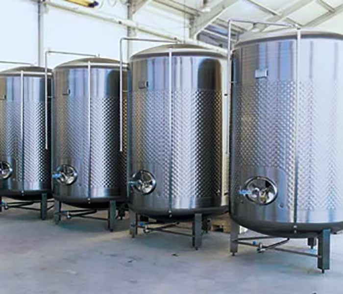 Four large stainless steel fermentation tanks.