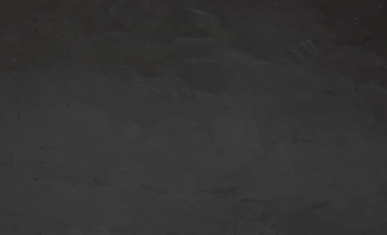 A very dark, almost black, textured surface with subtle variations in shading.