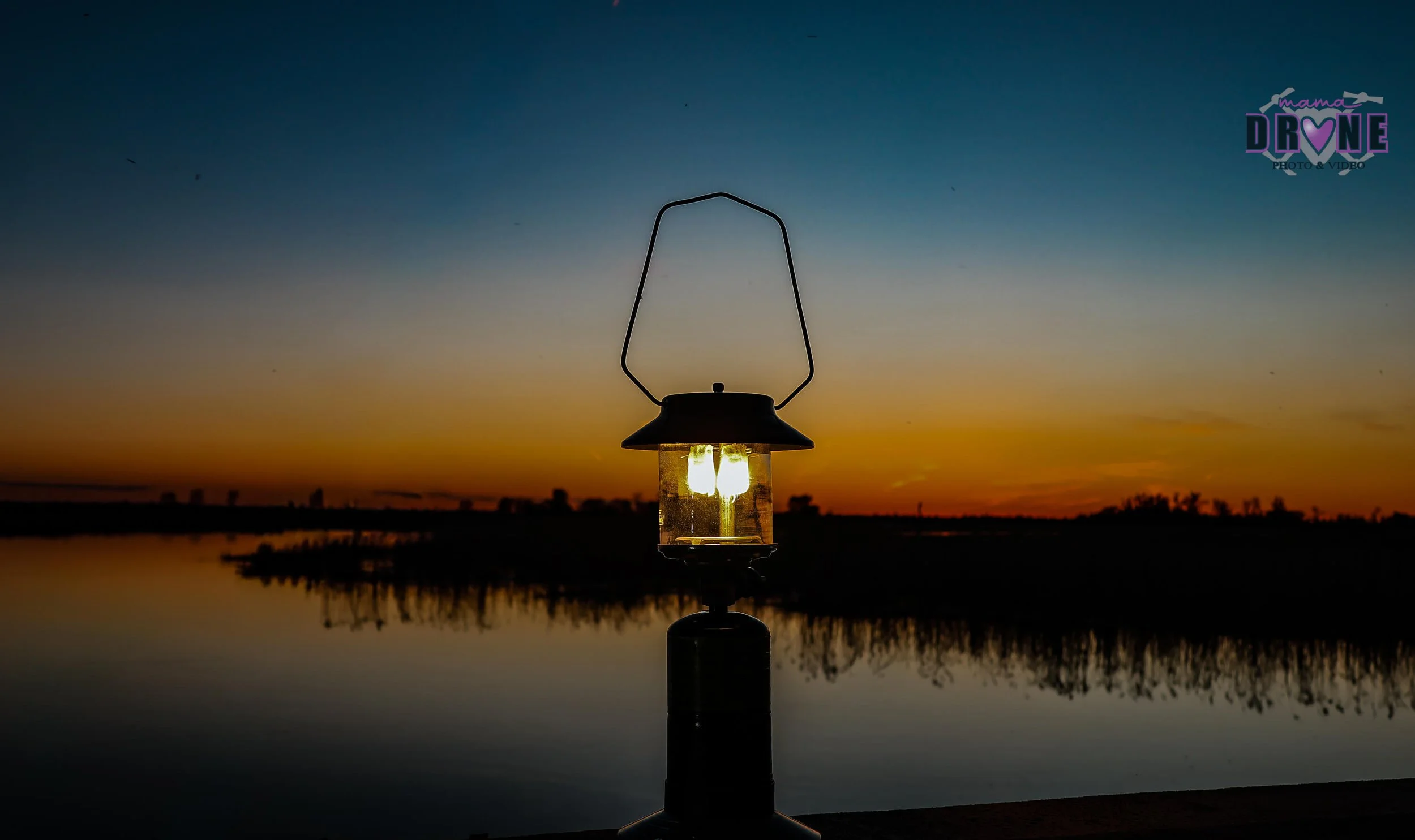 Sunset lattern with light on it near open water.